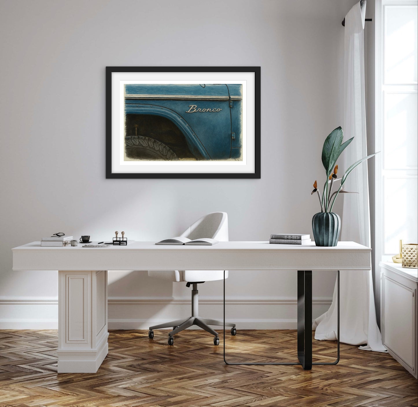 Modern office with a white desk, framed picture of a blue truck, and decorative elements.
