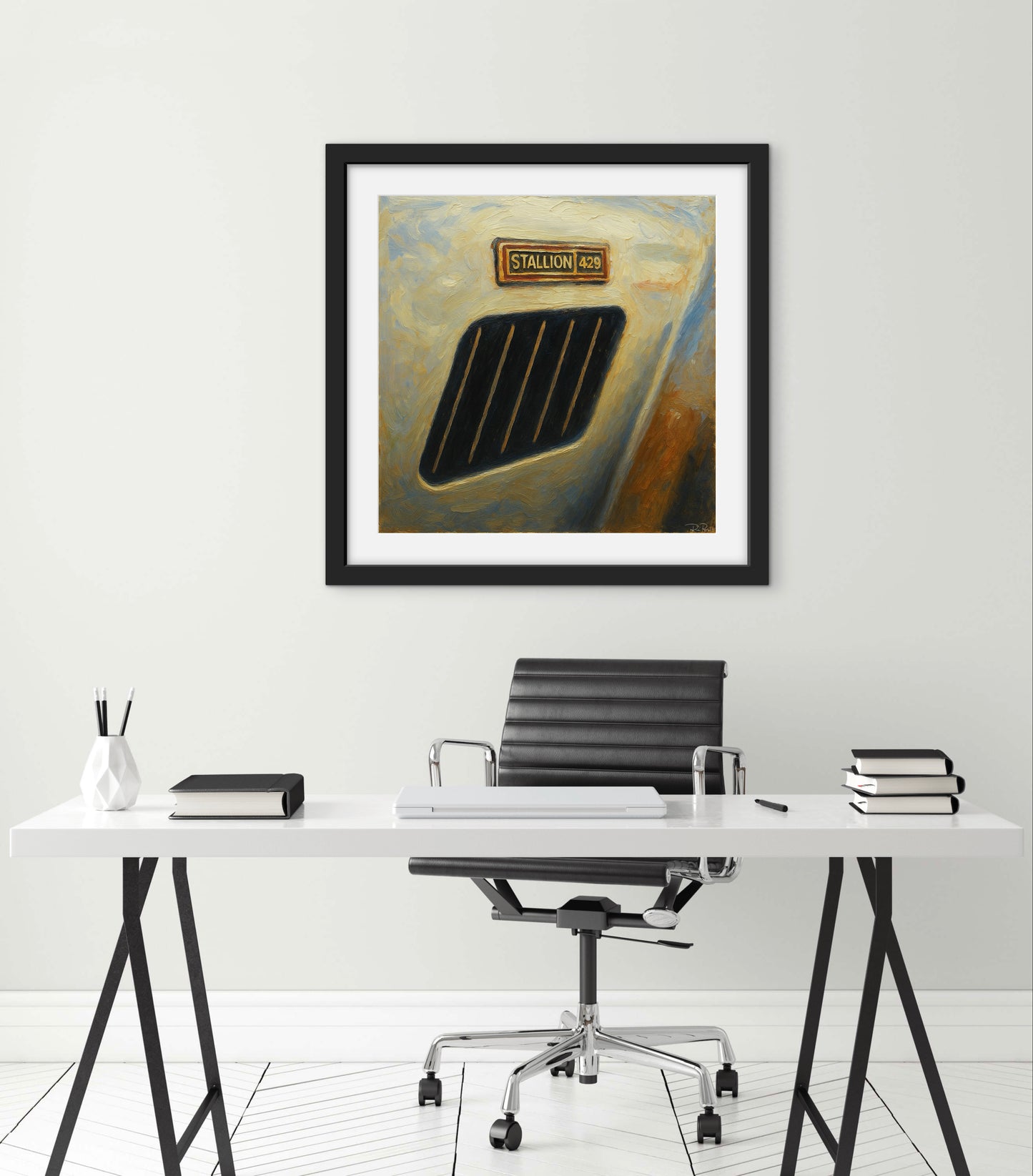 Framed artwork above a desk with office chair in a minimalistic room.