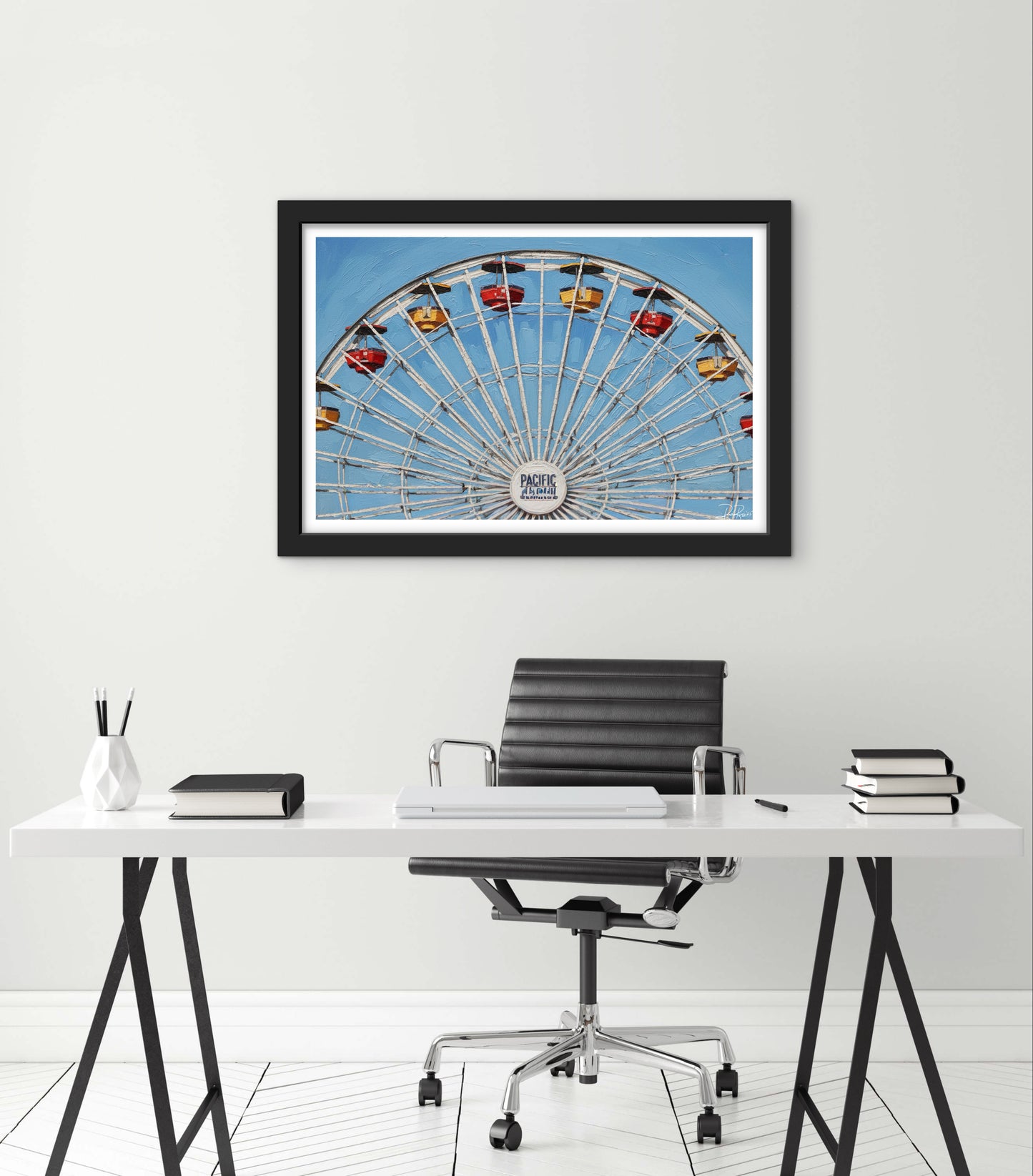 Framed photograph of a Ferris wheel above a modern office desk with a chair.