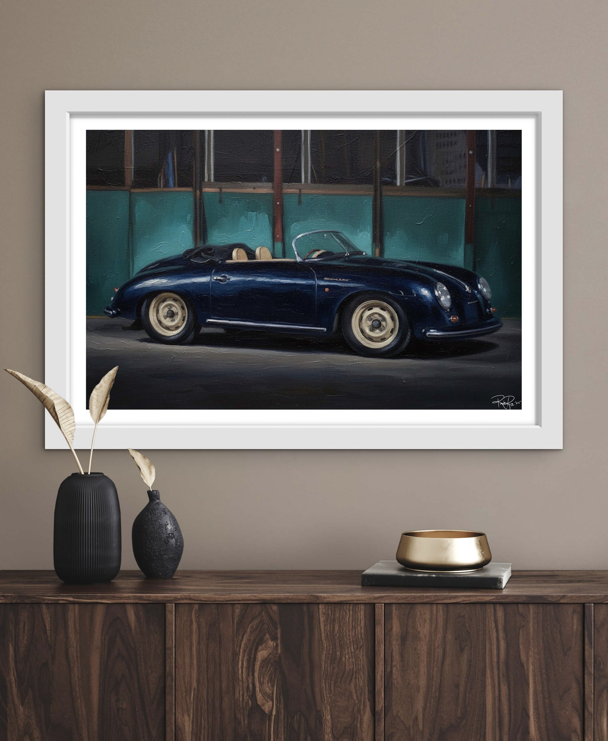 Framed artwork of a classic car on a wall above a wooden console table.