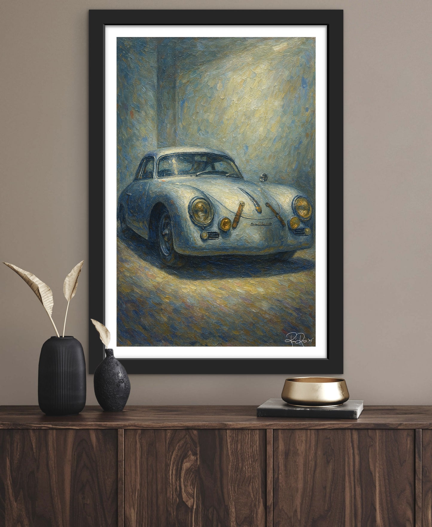 Framed painting of a vintage car on a wall above a wooden console table.