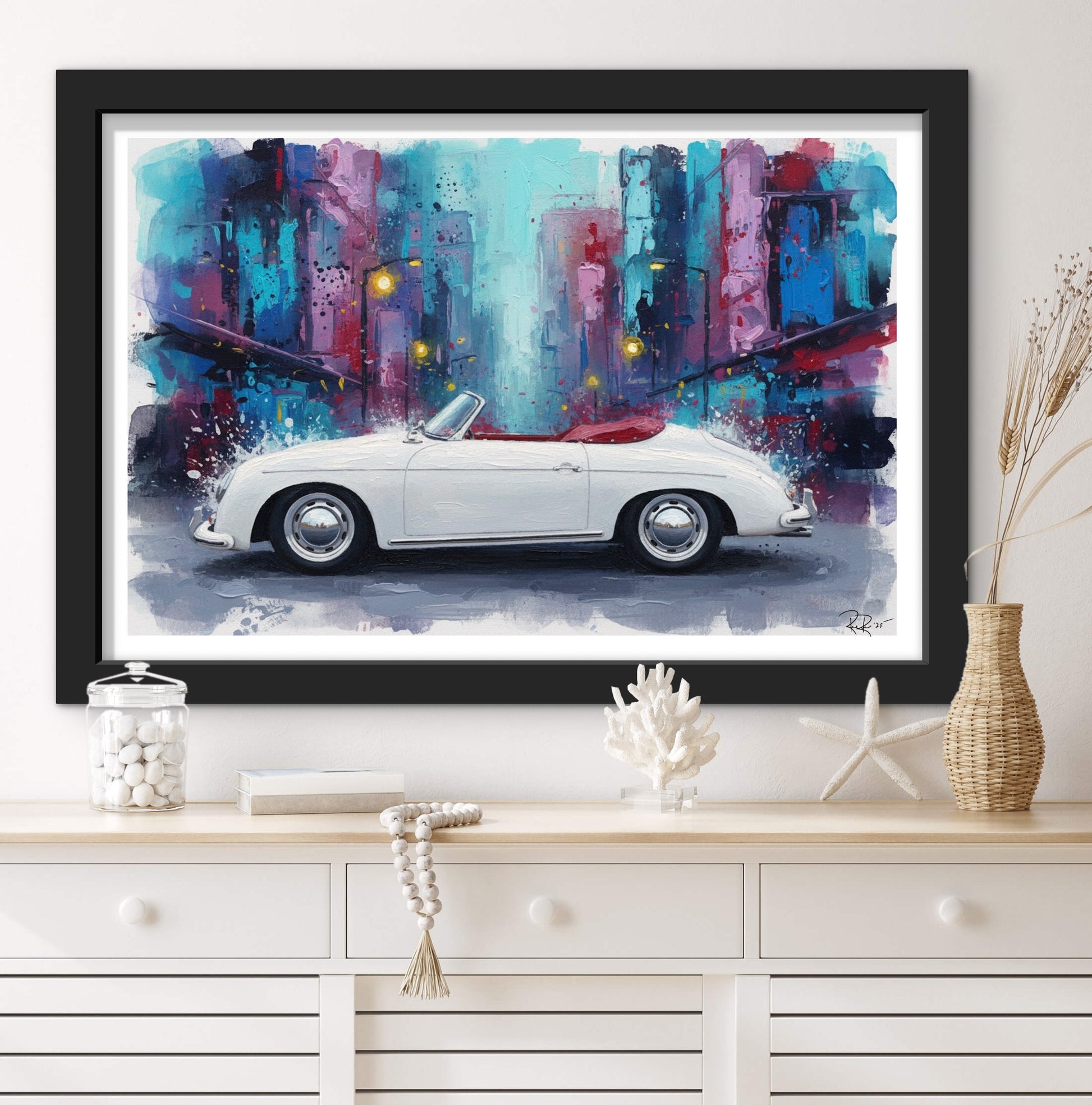 Framed artwork of a white convertible car against a colorful cityscape on a white wall.