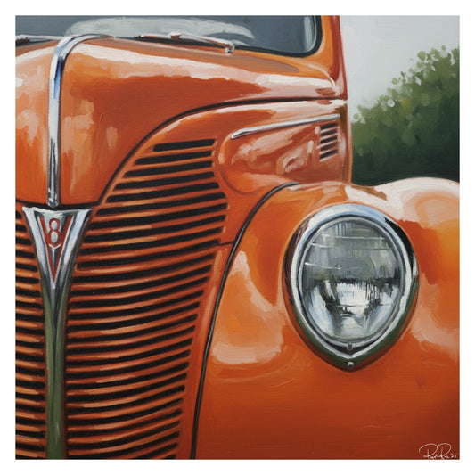 Close-up of an orange vintage car with a prominent grill and headlight.