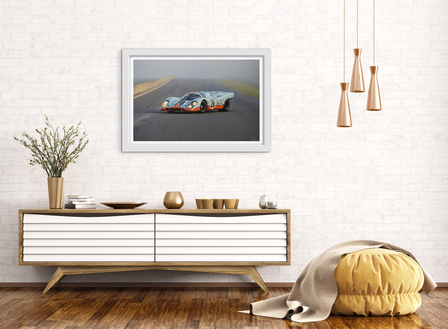 Framed photograph of a race car on a wall above a wooden console table.