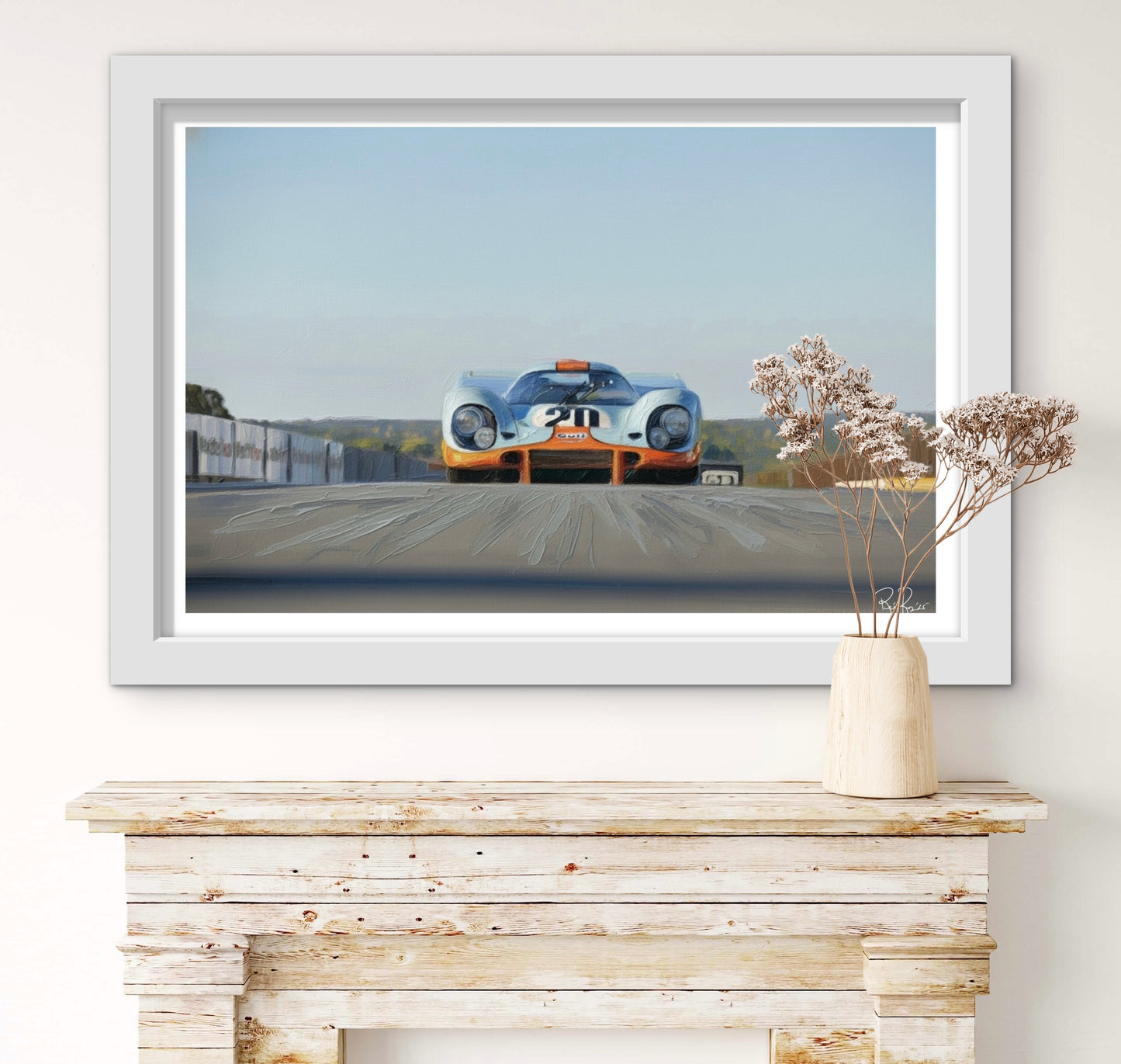 Framed artwork of a vintage race car on a wall above a wooden mantelpiece.
