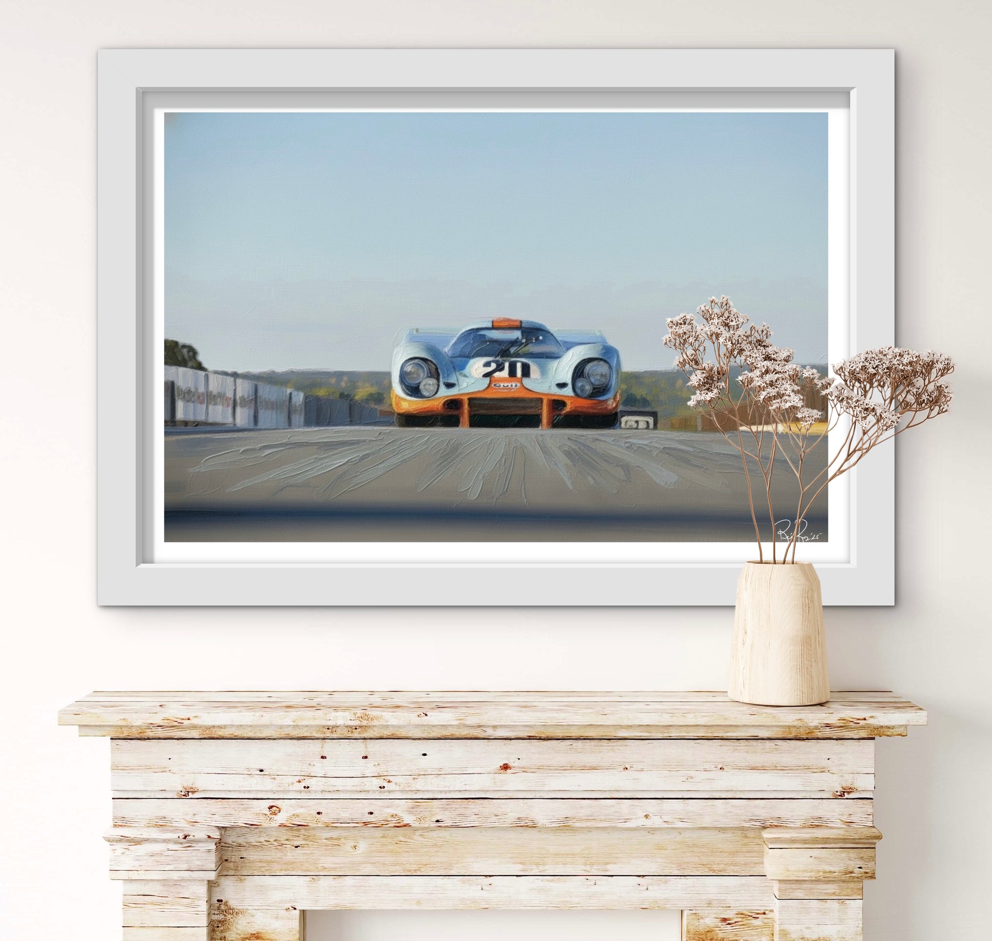 Framed artwork of a vintage race car on a wall above a wooden mantelpiece.