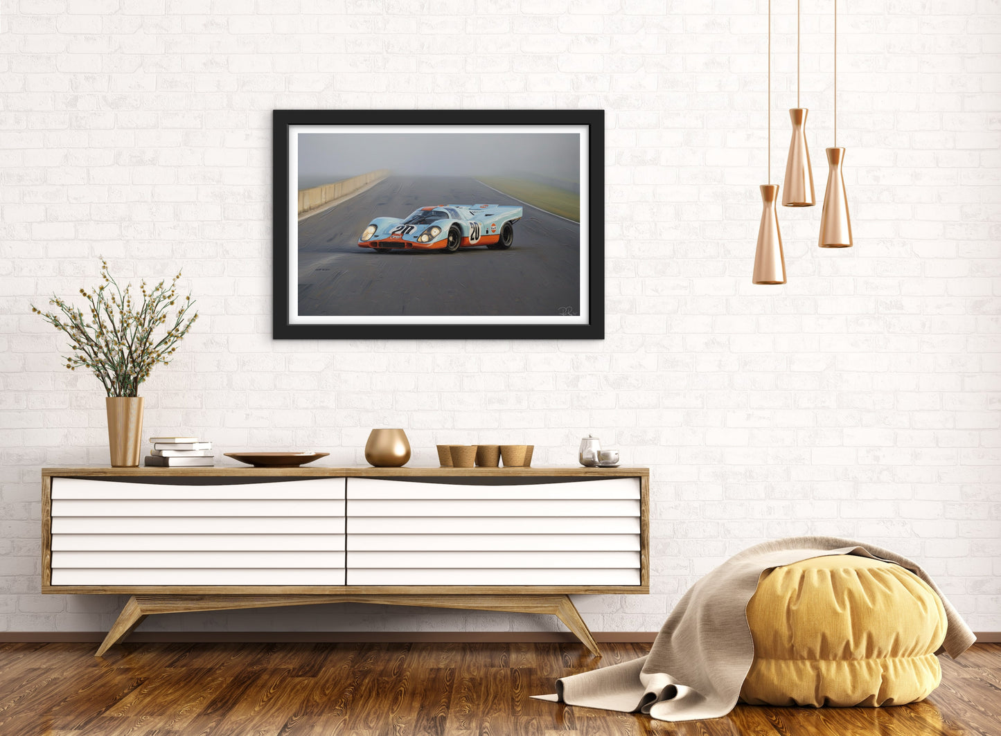 Framed picture of a race car on a wall above a wooden console table.