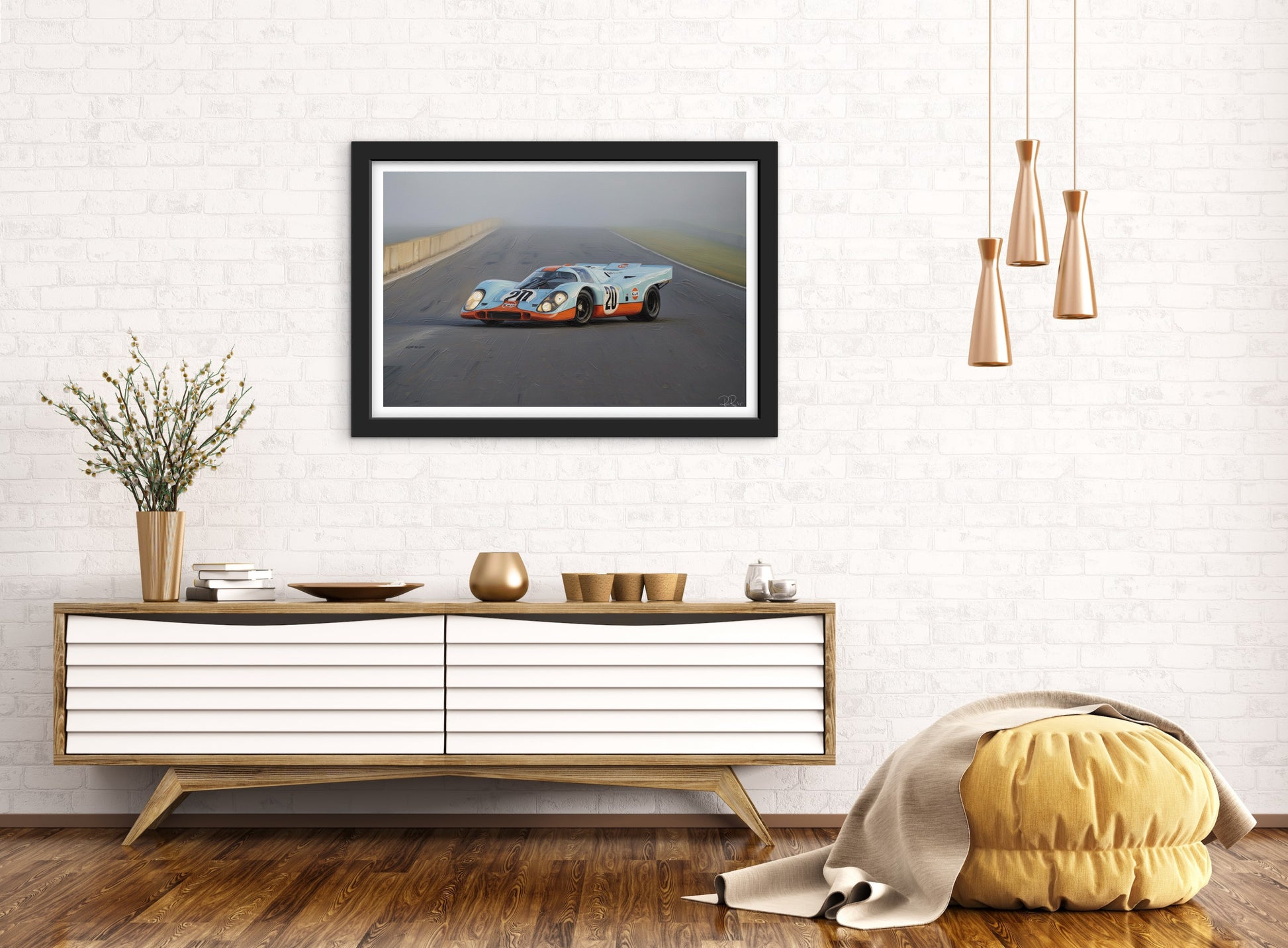 Framed picture of a race car on a wall above a wooden console table.