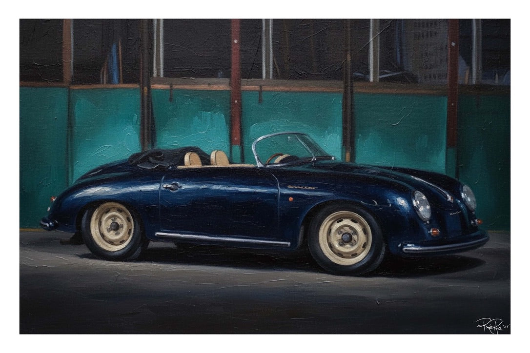 Blue vintage convertible car parked in front of a teal wall.