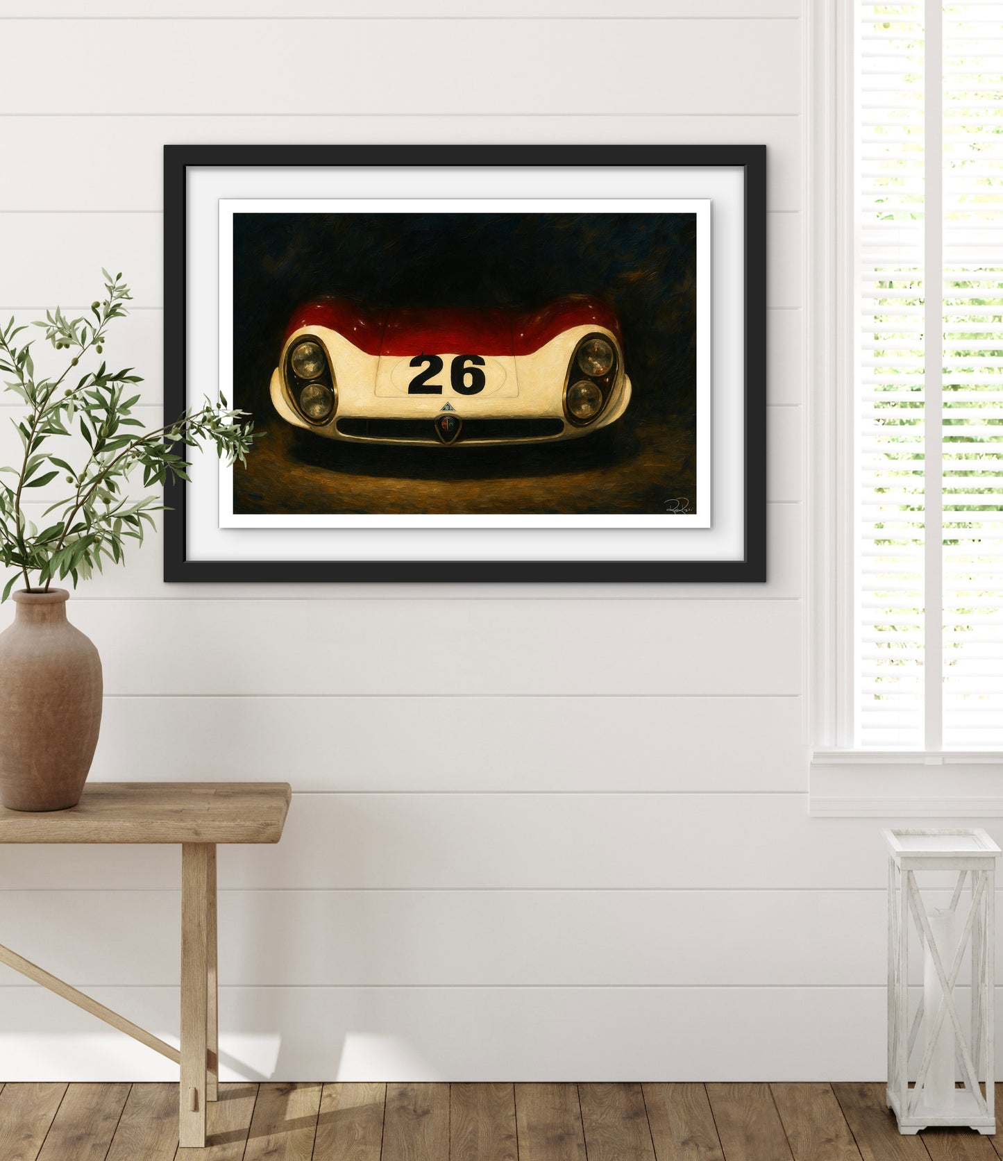 Framed artwork of a vintage race car on a white wall with a wooden floor.