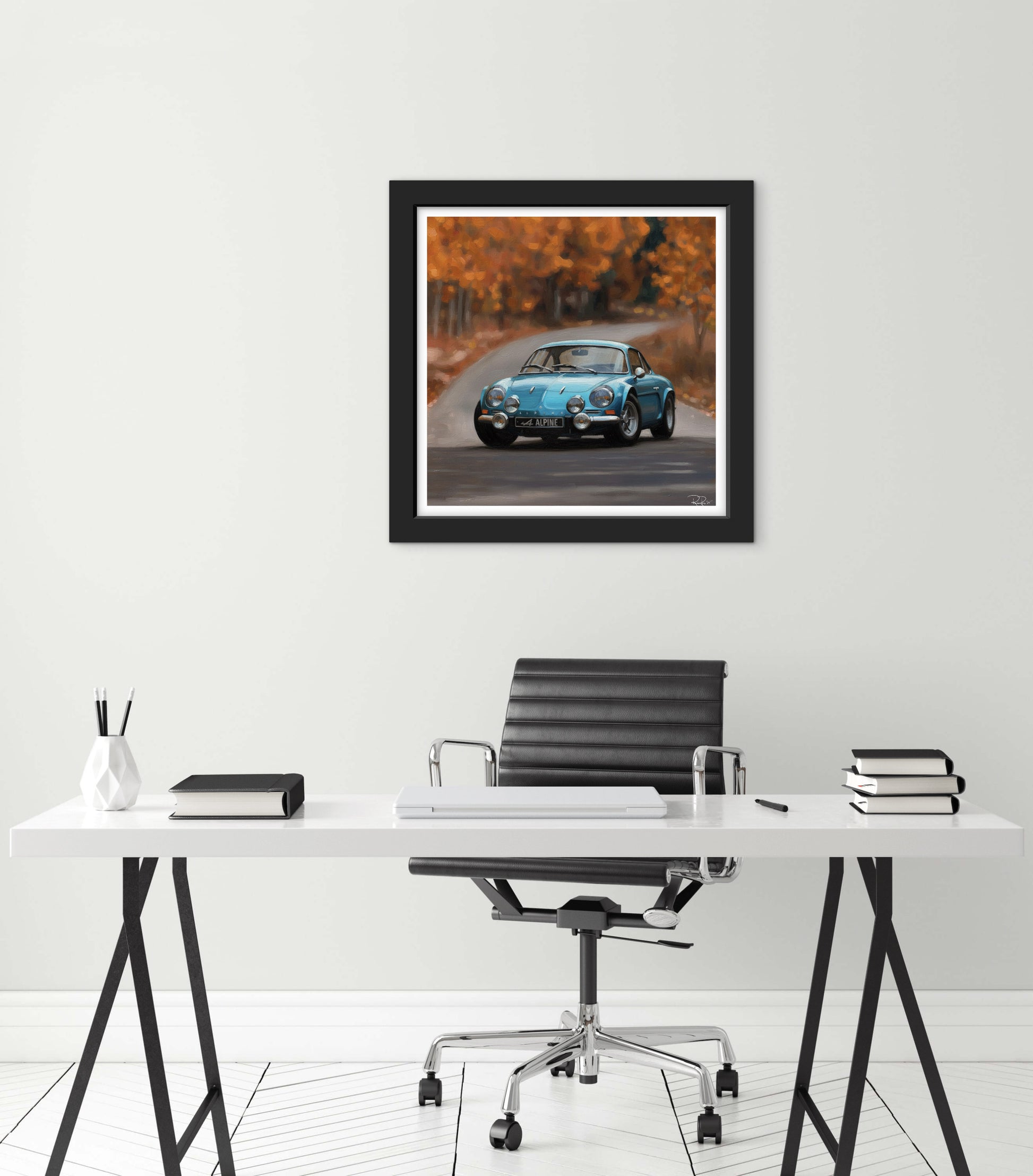 Framed artwork of a vintage car on an autumn road above a modern office desk.