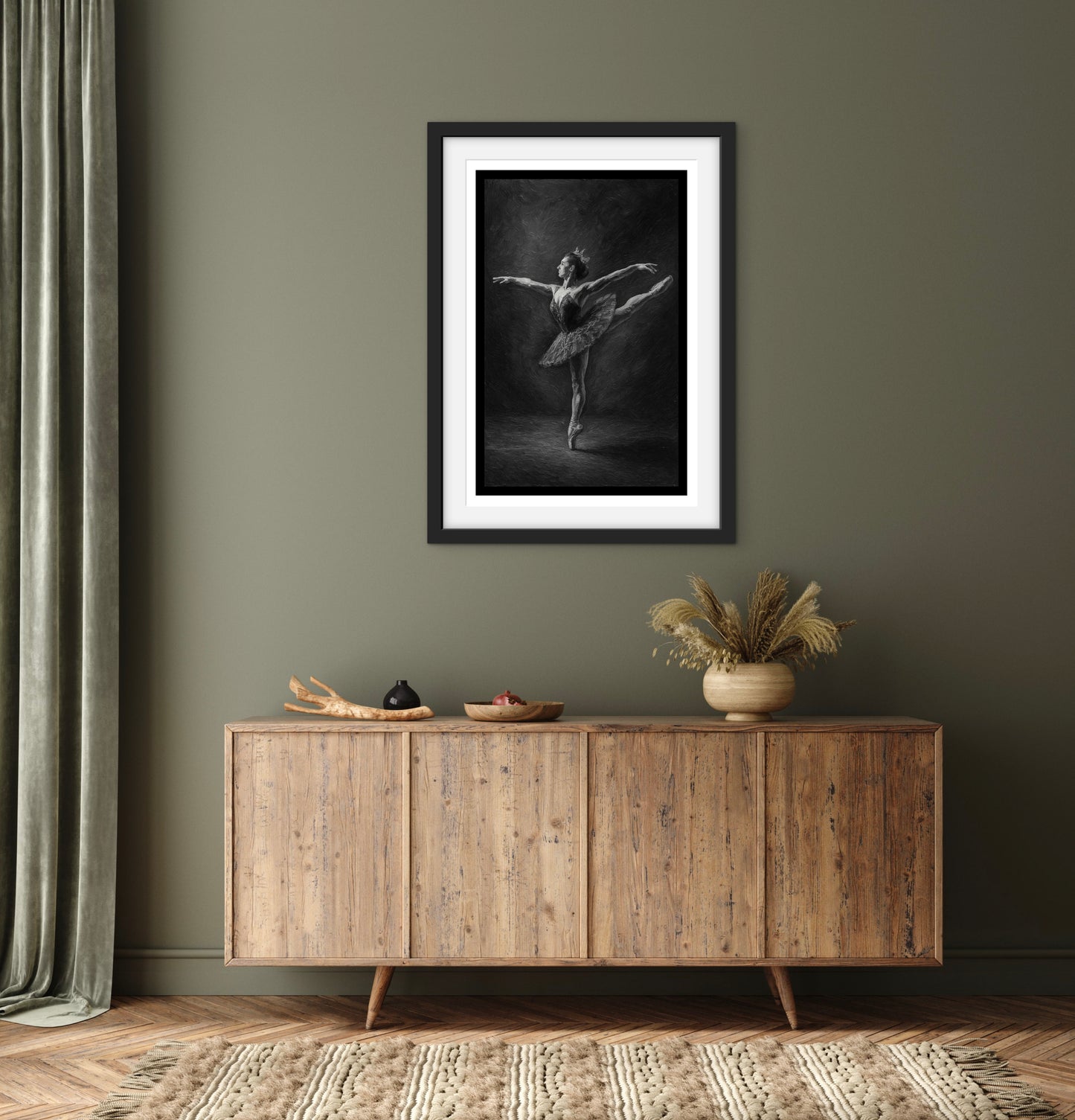Framed black and white artwork of a dancer above a wooden sideboard in a room with a curtain.