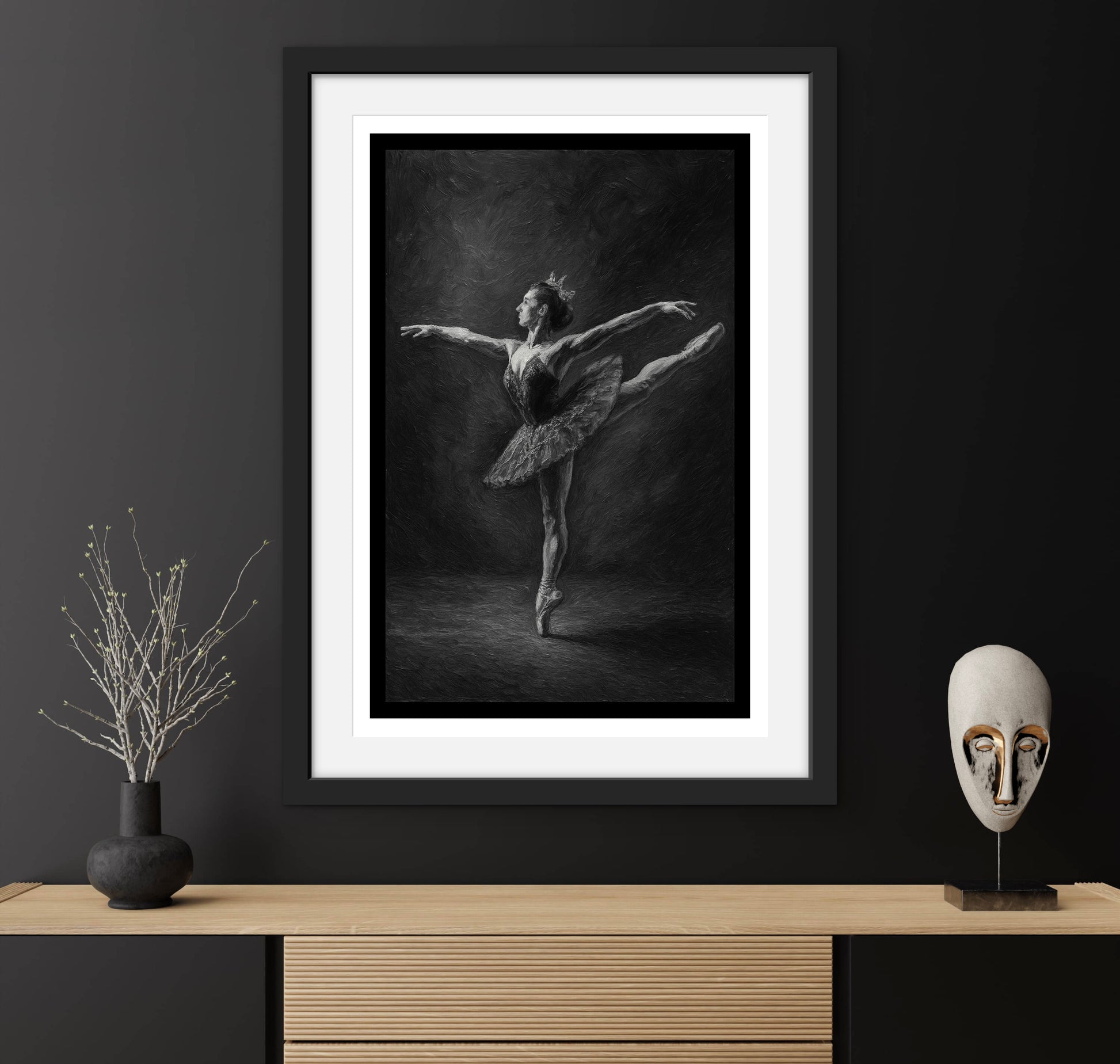 Framed black and white ballet dancer print on a dark wall with decorative items.