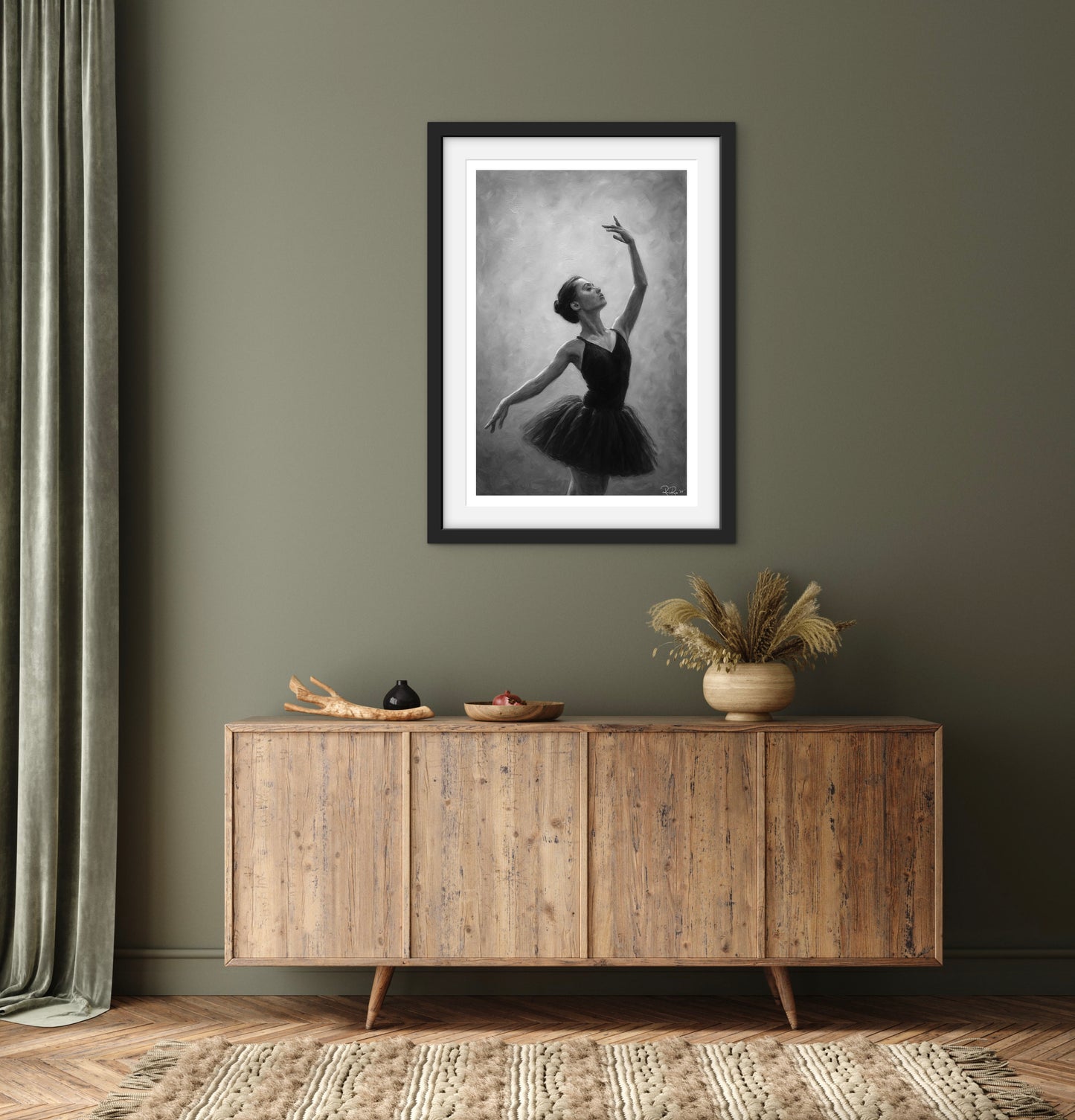 Framed black and white artwork of a dancer on a wall above a wooden sideboard.