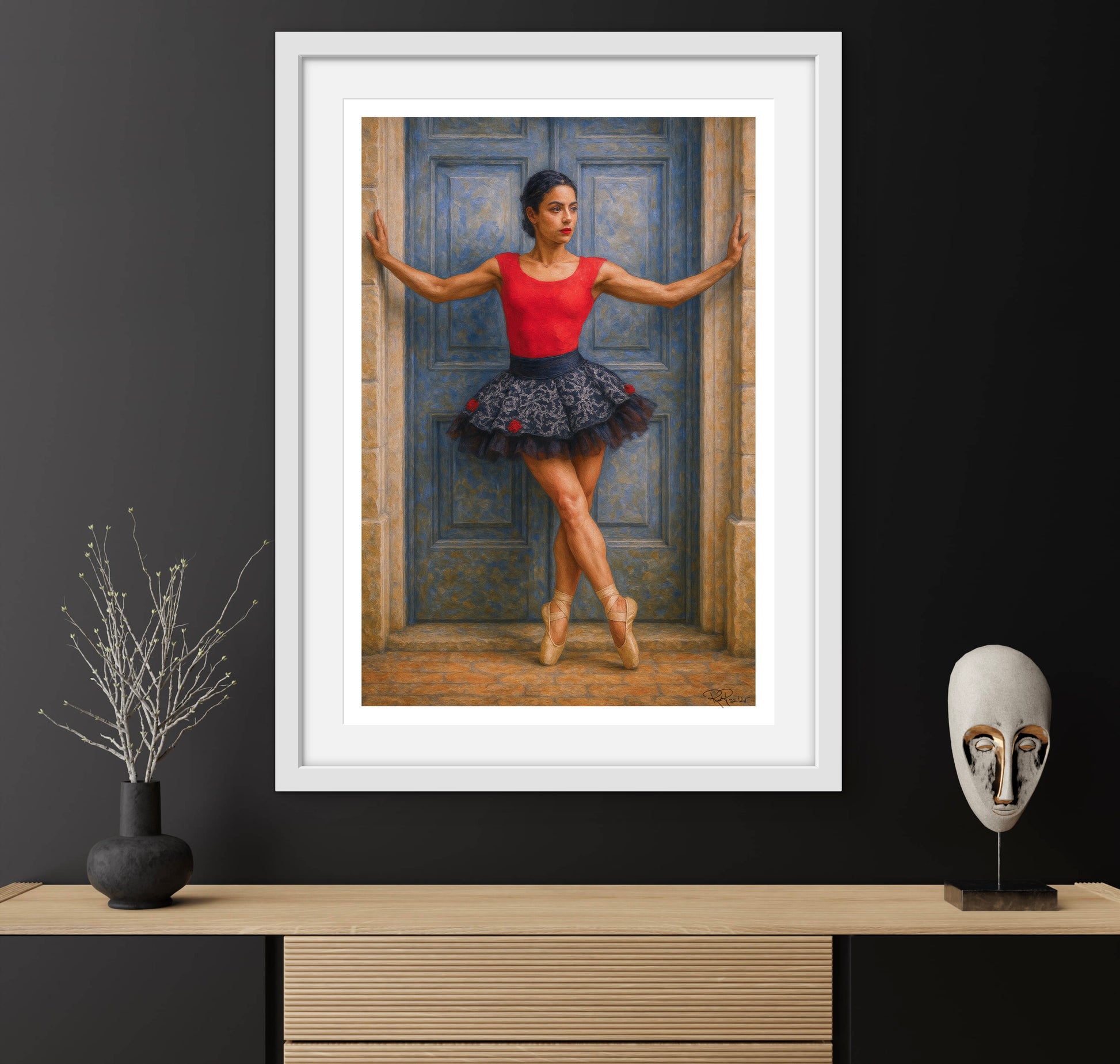 Framed artwork of a dancer in a red top and black skirt against a blue door, displayed on a dark wall with decorative items.