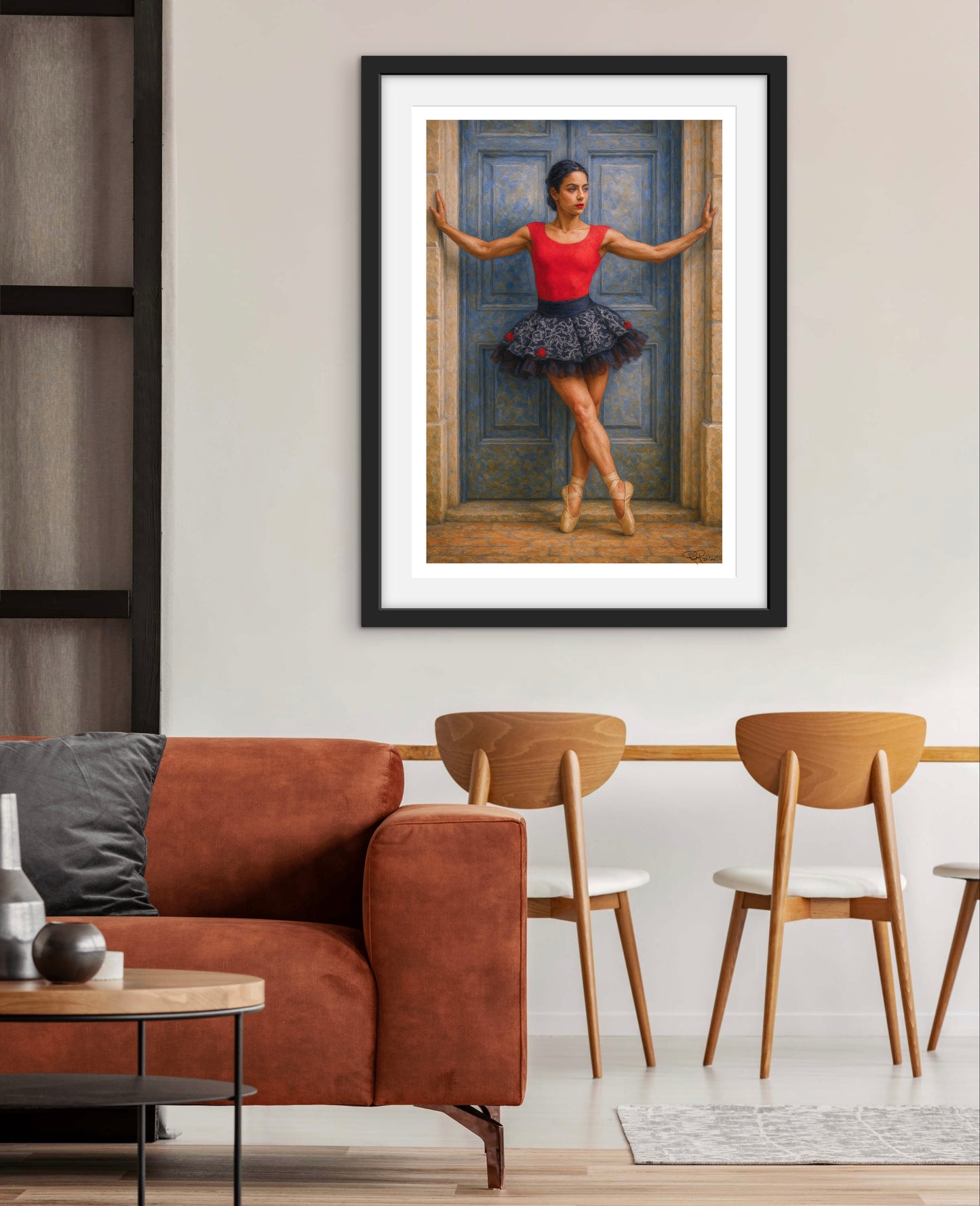 Framed artwork of a ballerina in a living room setting with a brown sofa and wooden chairs.