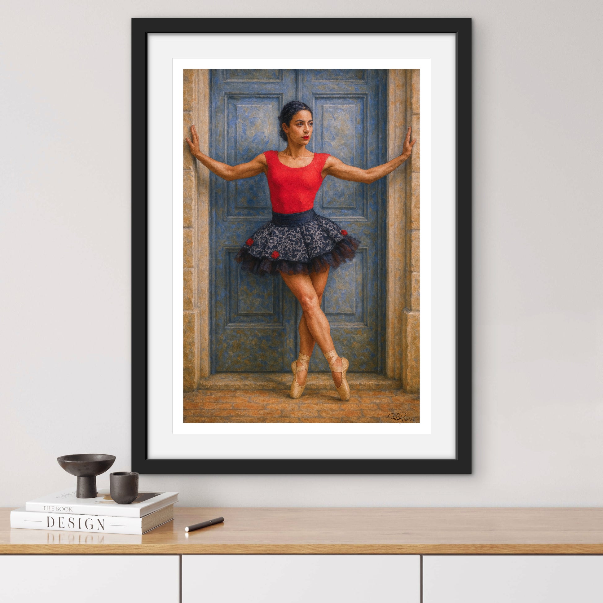 Framed artwork of a ballerina in a red top and blue tutu against a blue door.