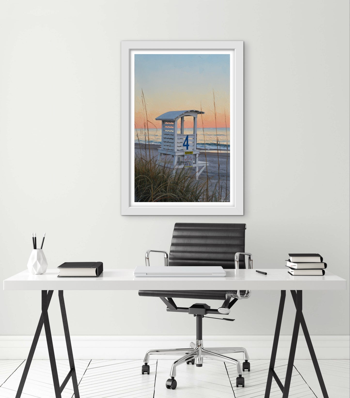 Framed artwork of a beach scene above a desk with office furniture.