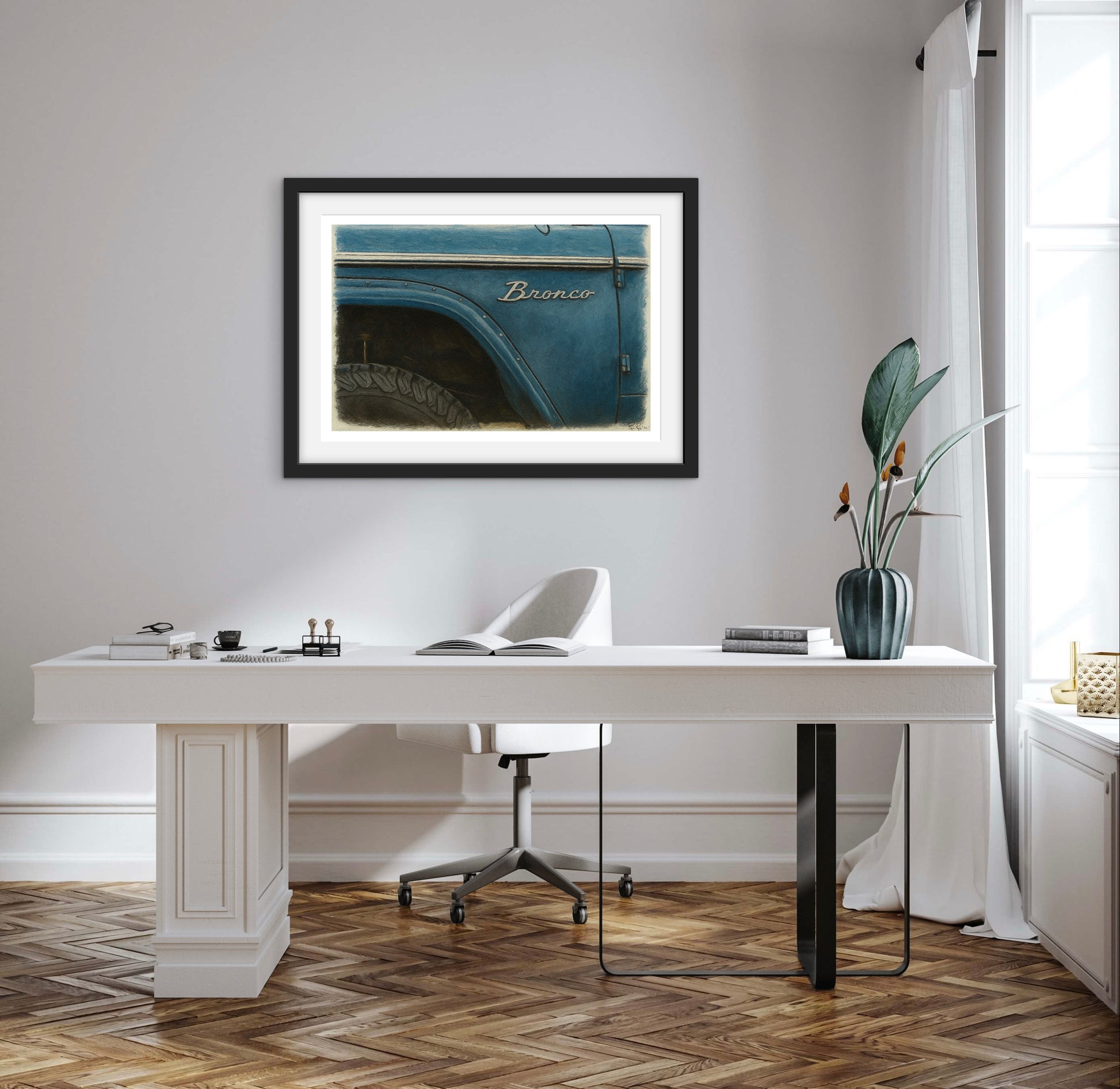 Modern office with a white desk, framed picture of a blue truck, and decorative elements.