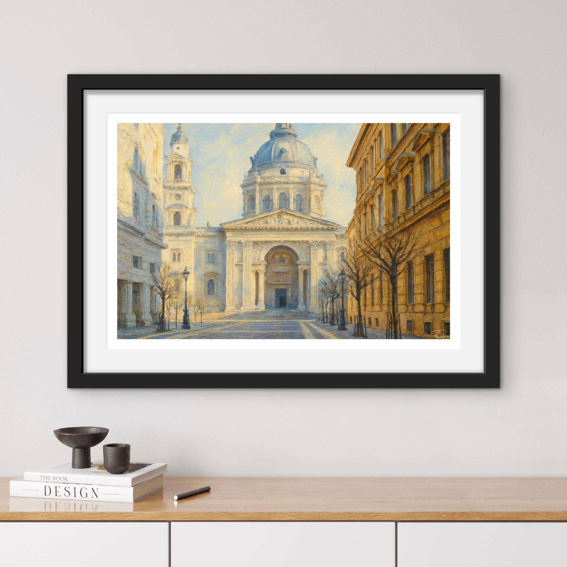 Framed artwork of a classical building on a wall above a wooden shelf.
