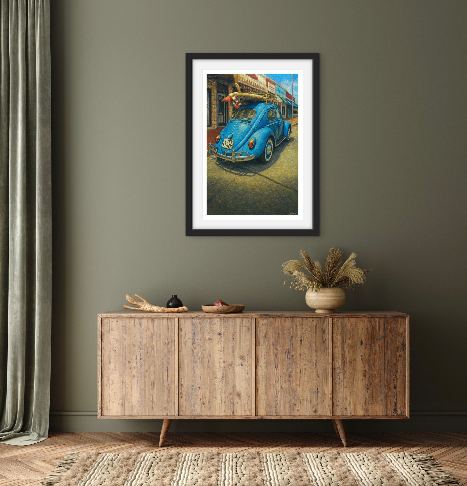 Framed artwork of a blue car on a wall above a wooden sideboard.