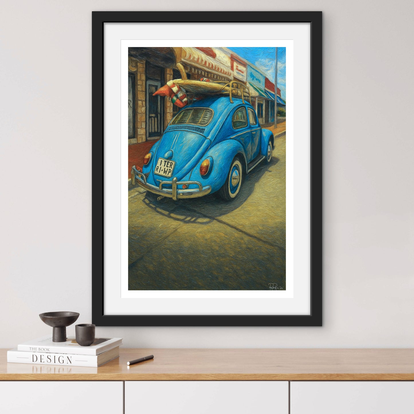 Framed artwork of a blue vintage car with surfboards on a city street.