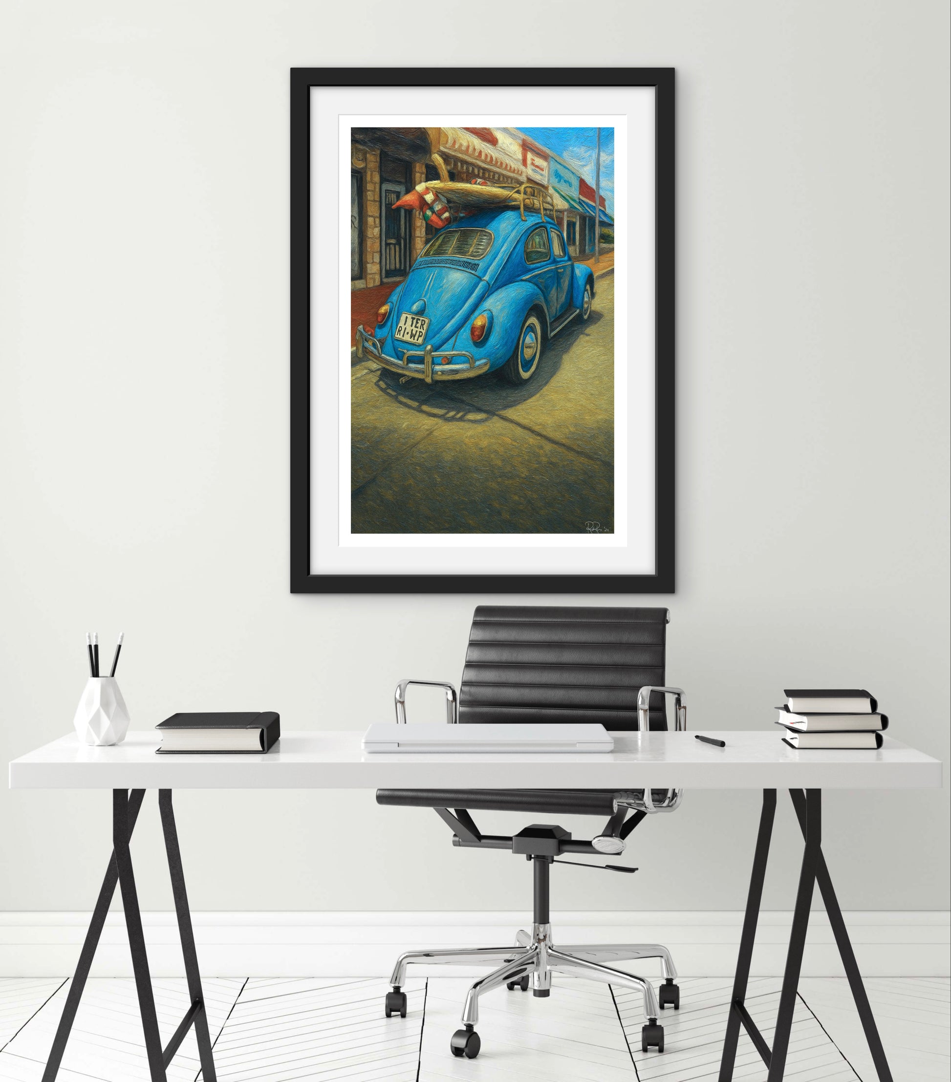 Framed artwork of a blue vintage car on a wall above a desk.