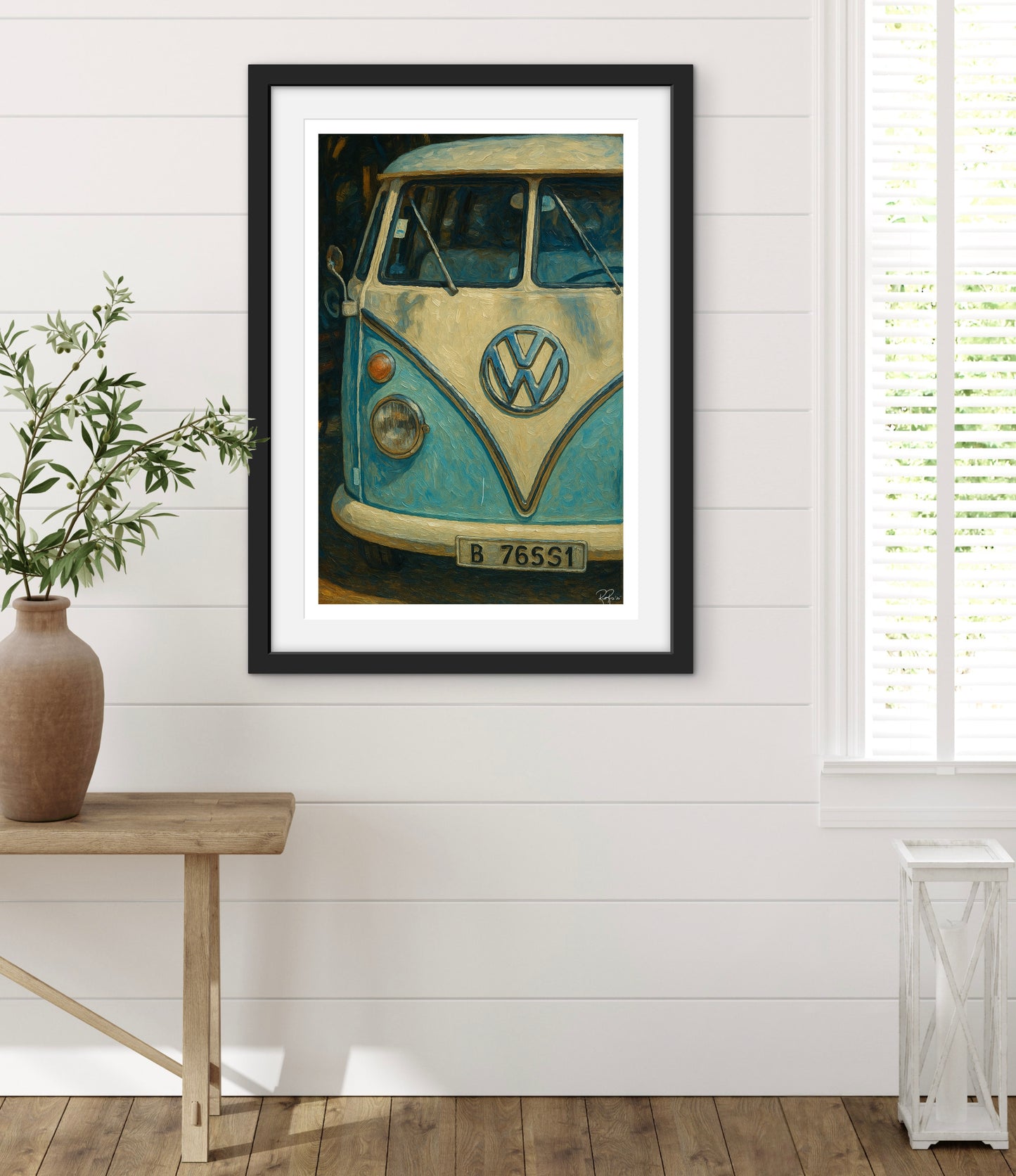 Framed artwork of a vintage Volkswagen bus on a white wall with a wooden bench and plant.