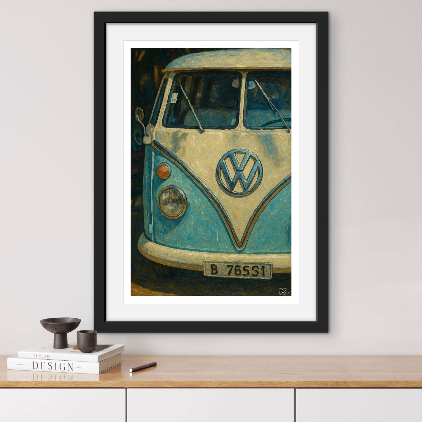 Framed artwork of a vintage Volkswagen van on a wall above a wooden shelf.