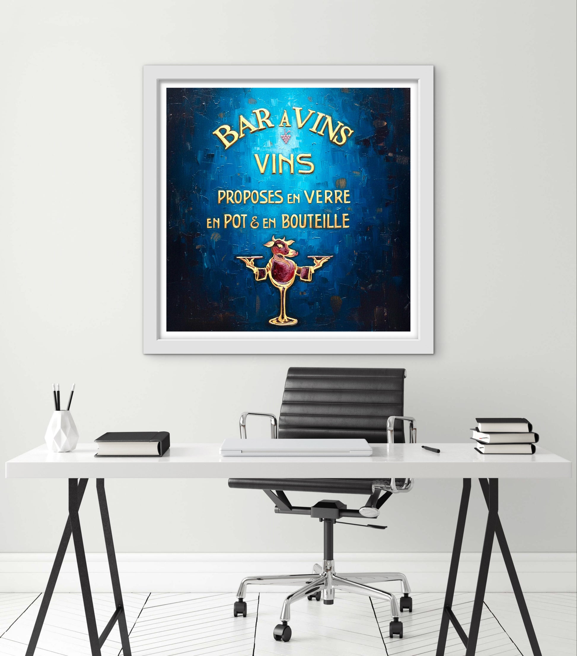 Framed artwork with a blue background and text on a white wall above a desk.