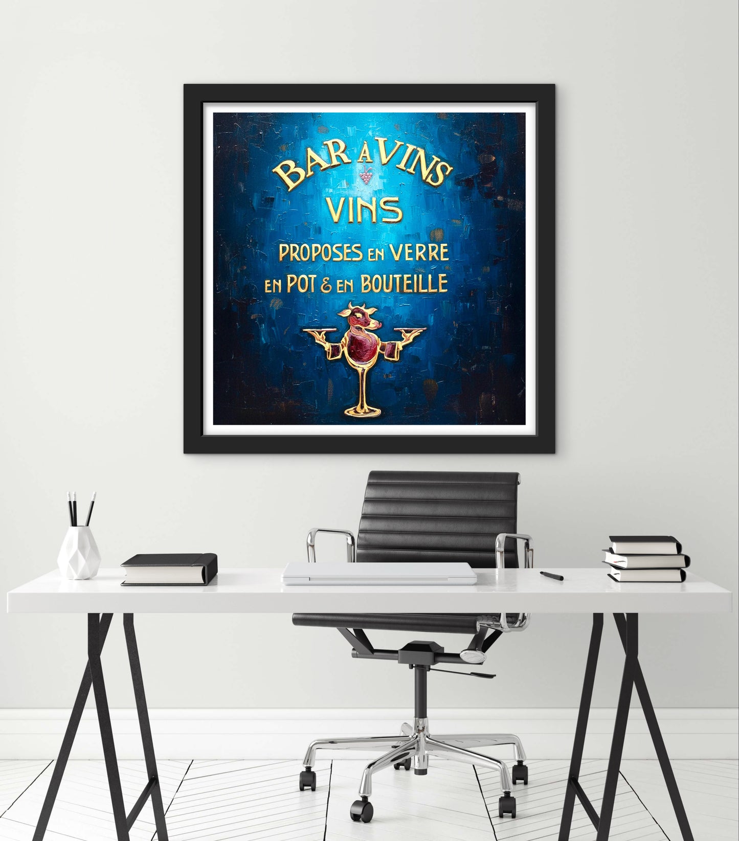 Framed artwork with a blue background and text on a white wall above a desk.
