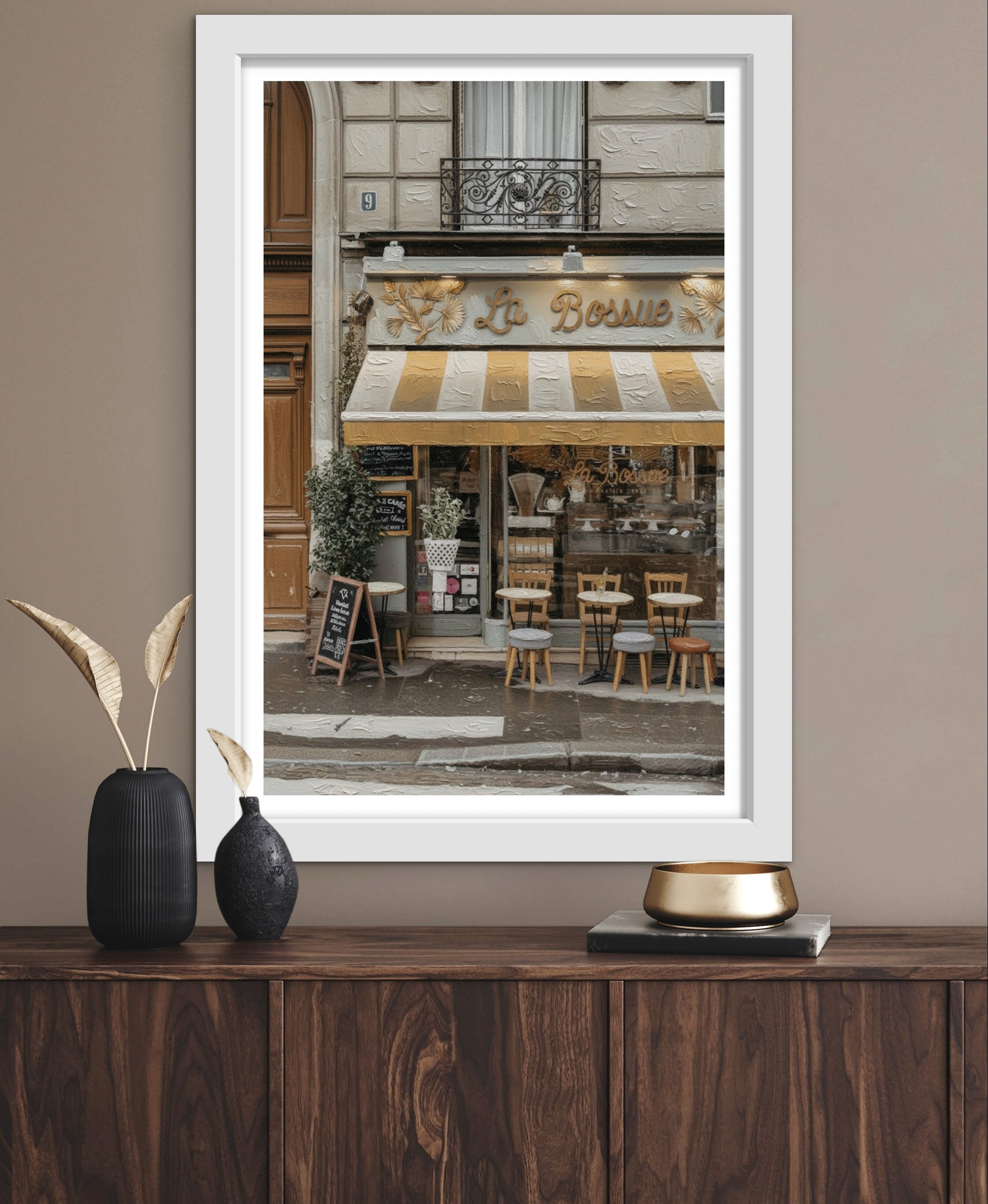 Framed photograph of a café on a wooden surface with decorative items.
