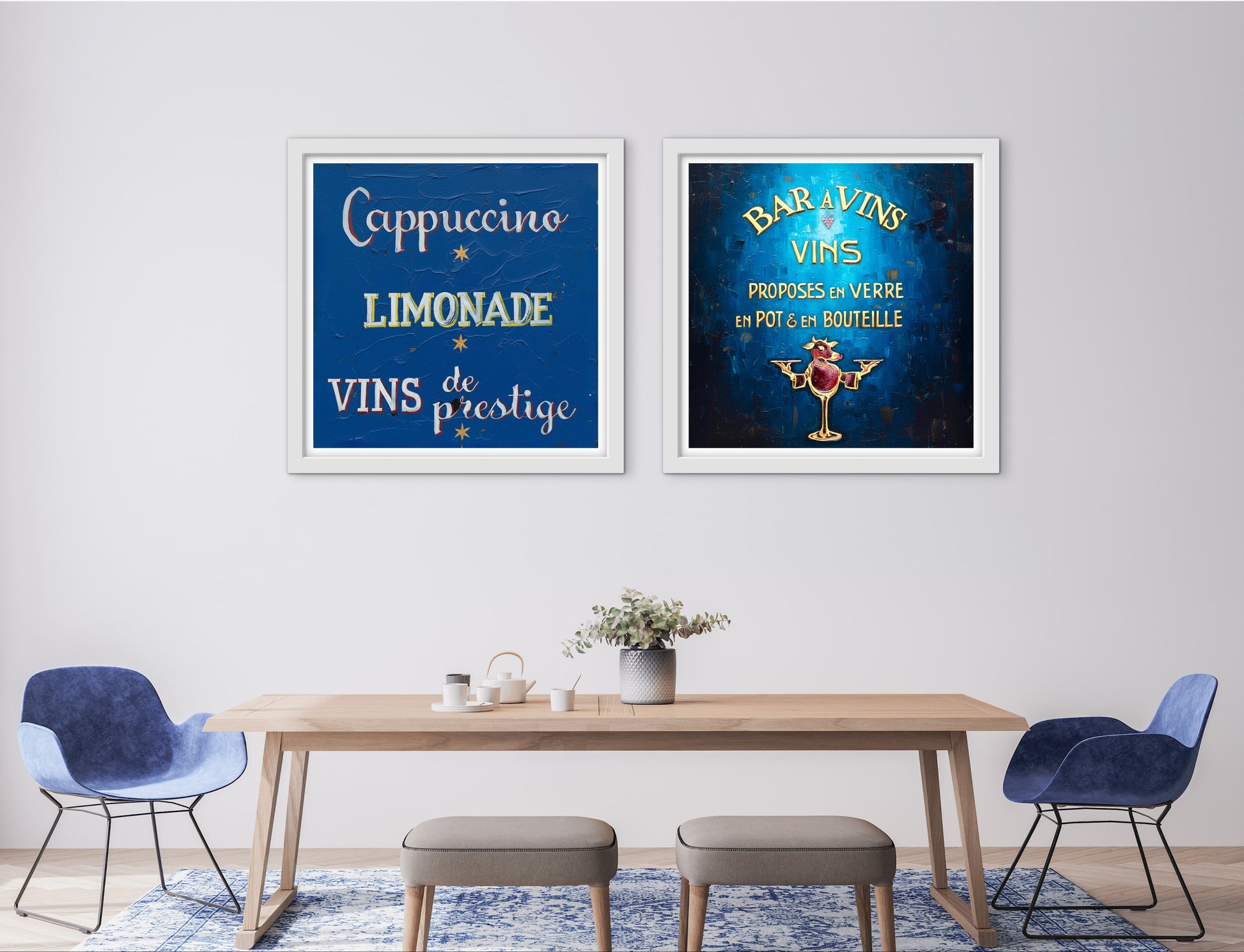 Two framed posters on a wall above a dining table with chairs.