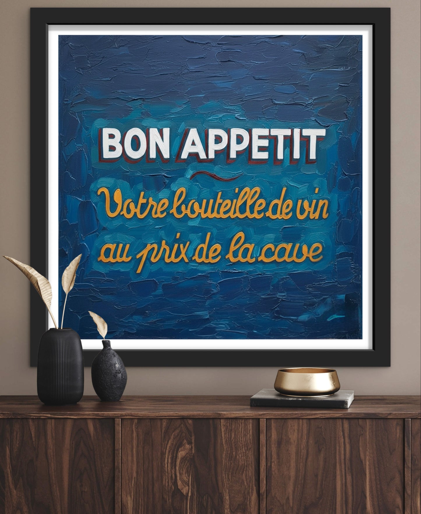 Framed artwork with 'Bon Appetit' text on a blue background, displayed on a wooden shelf.