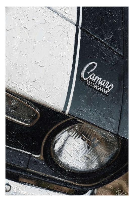 Close-up of a car's headlight and 'Camaro' badge on a white and black background