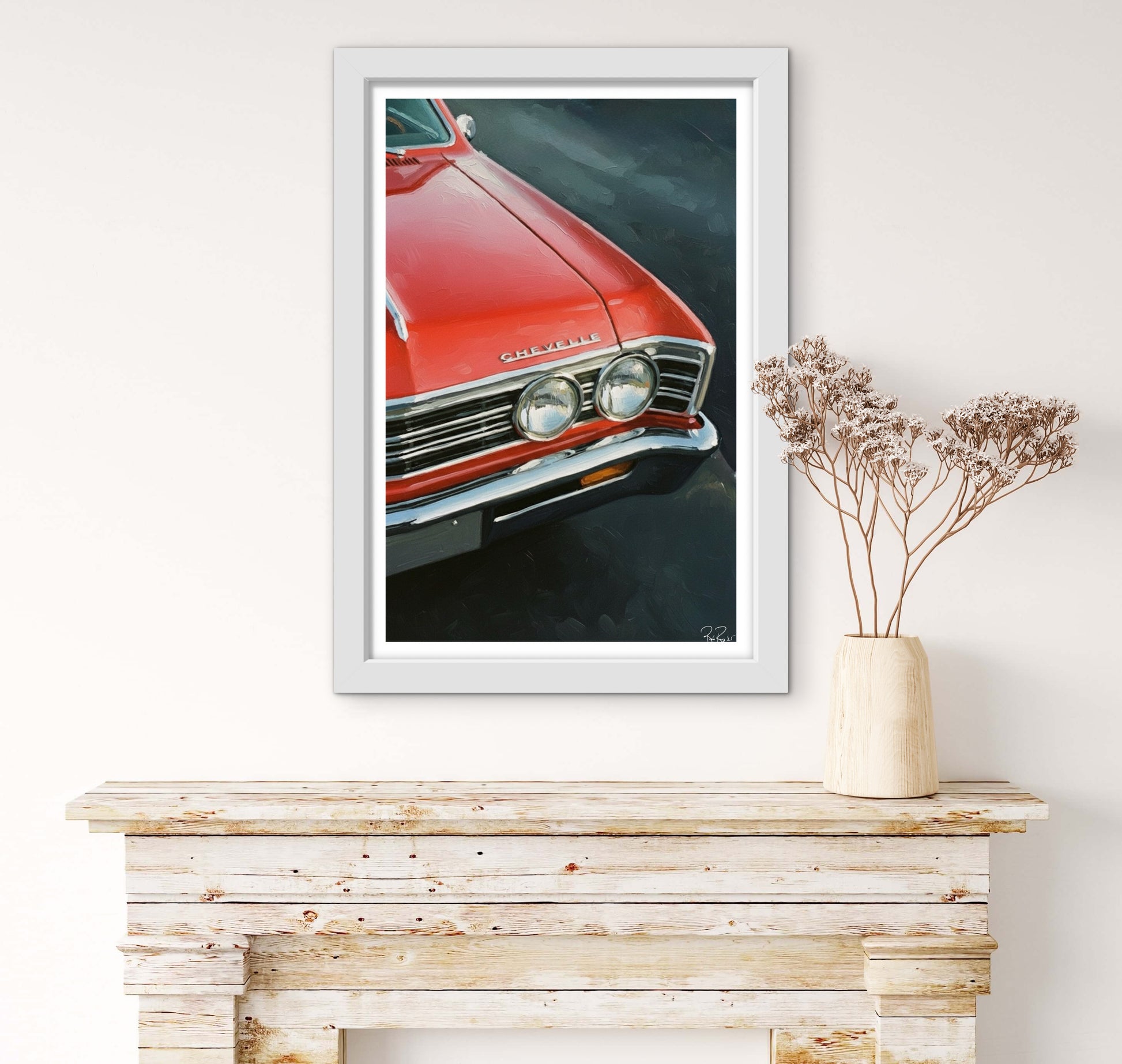 Framed picture of a red car on a wooden shelf with a vase of flowers.