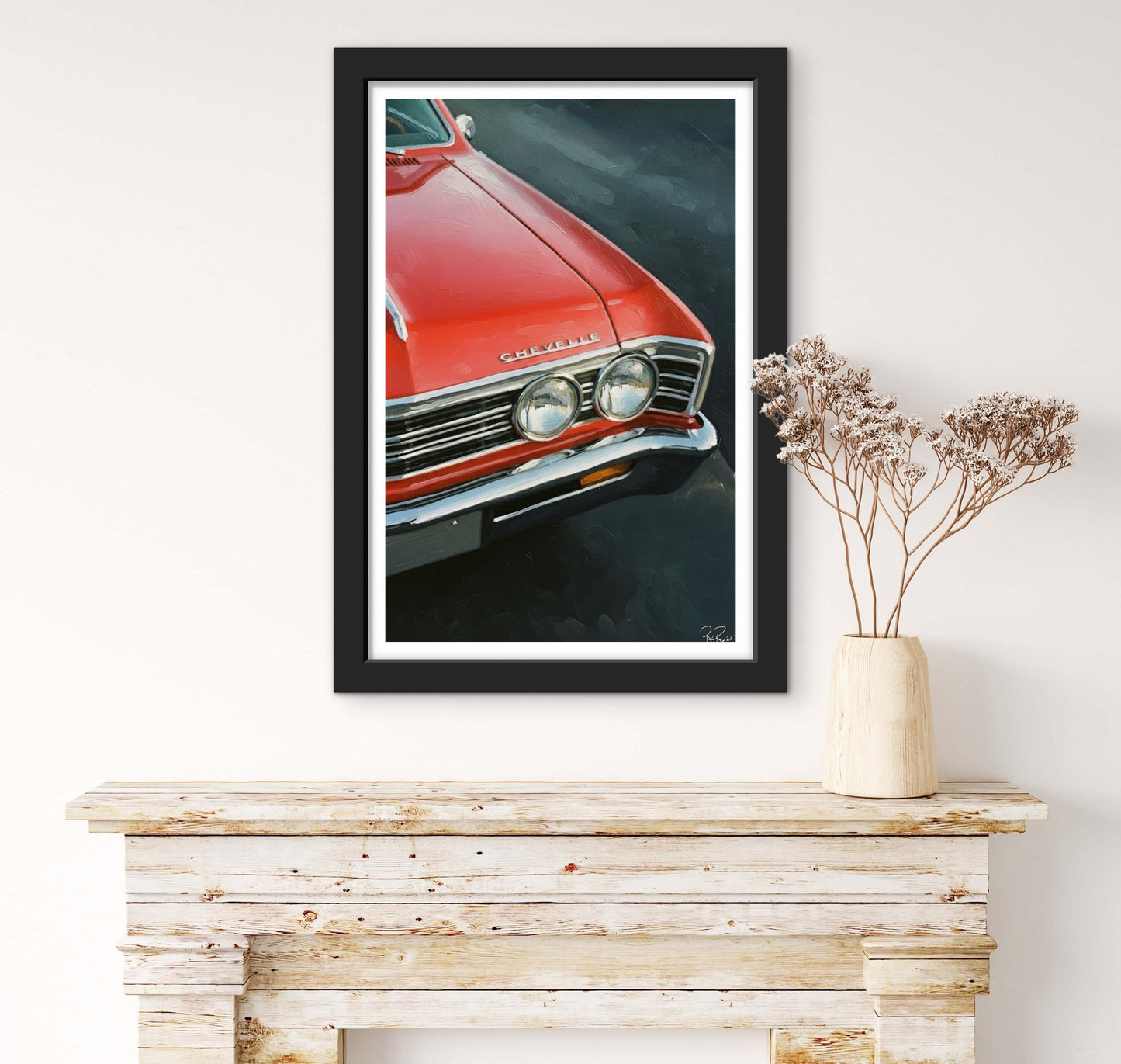 Framed artwork of a red car on a wall above a wooden console table with a vase.