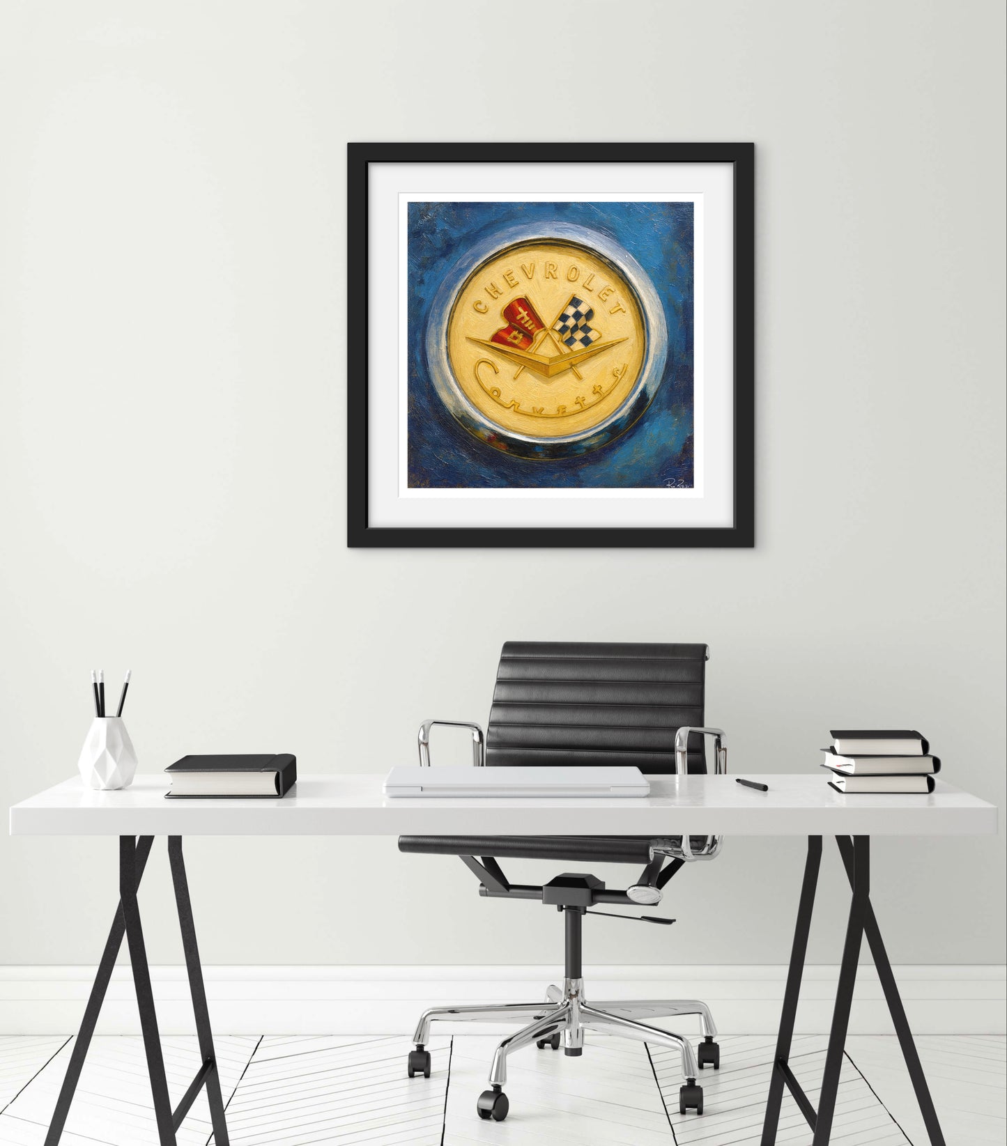 Framed artwork of a vintage Chevrolet logo on a wall above a desk.