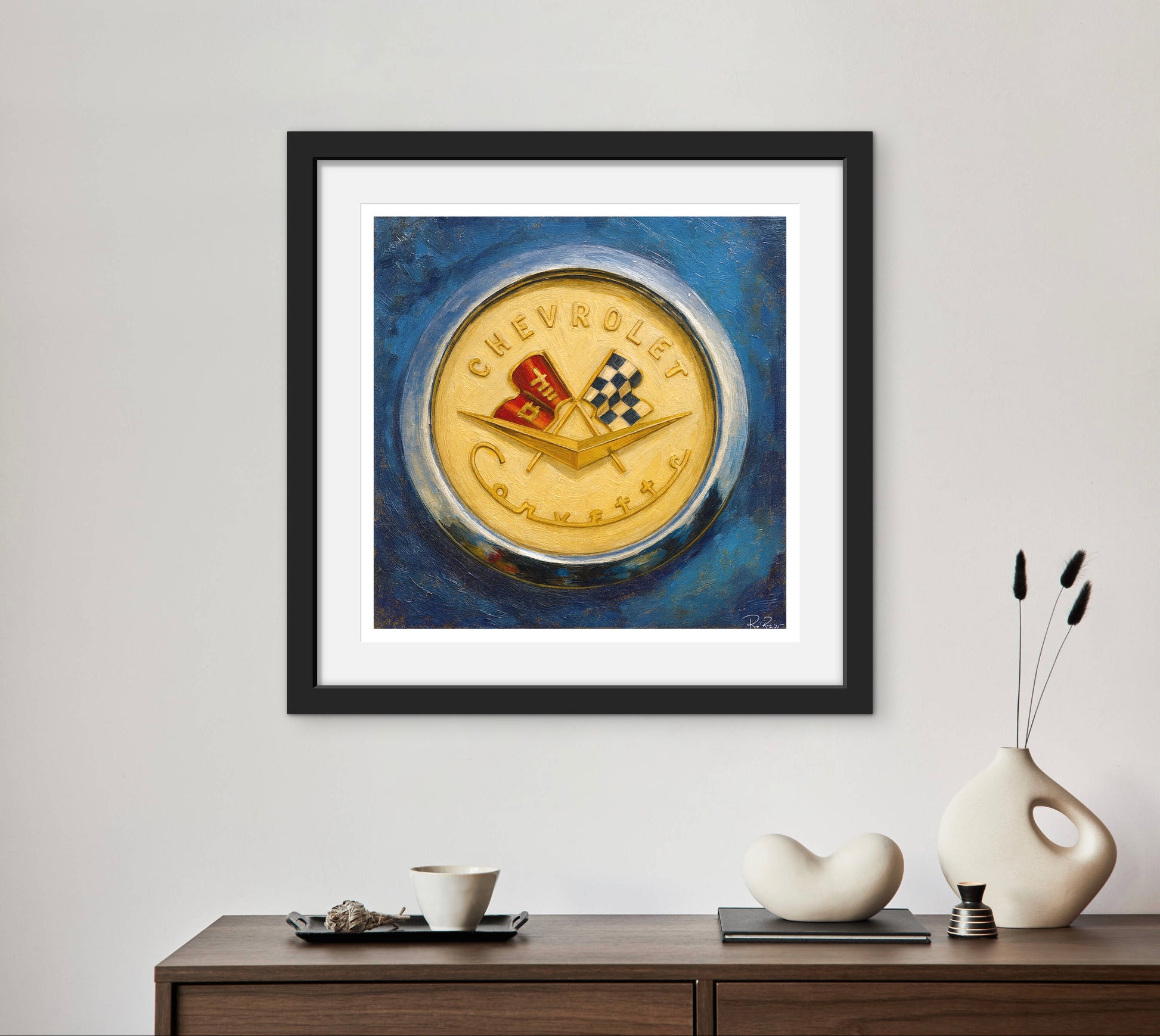 Framed artwork of a Chevrolet logo on a blue background, displayed on a wall above a wooden console table.