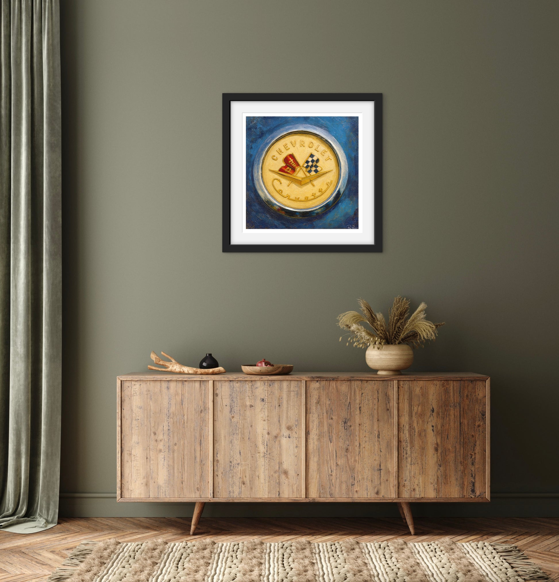 Framed artwork on a wall above a wooden sideboard with decorative items.