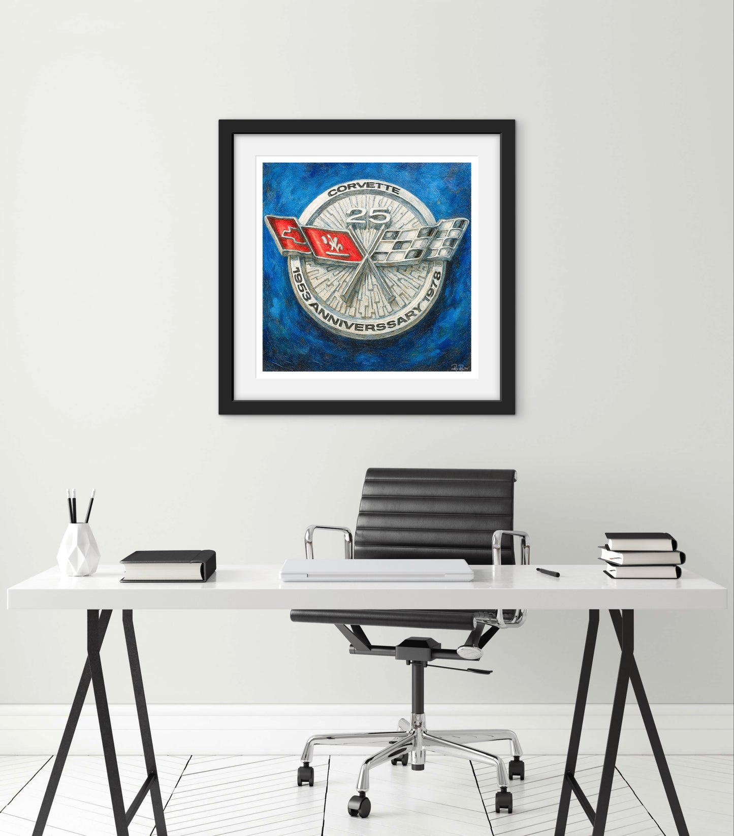 Framed artwork of a Corvette logo on a wall above a desk.