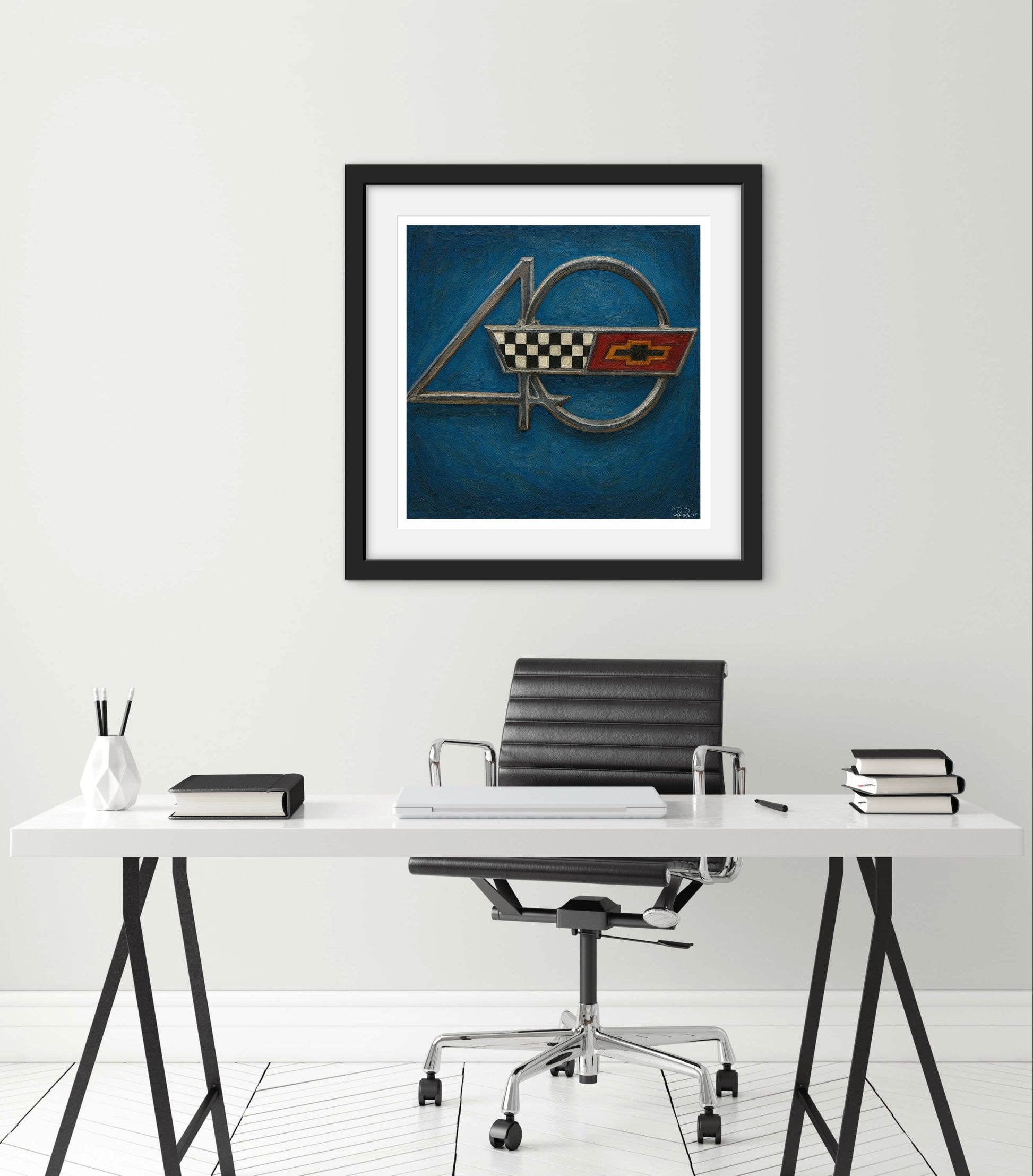 Framed artwork of a car emblem above a desk with office chair