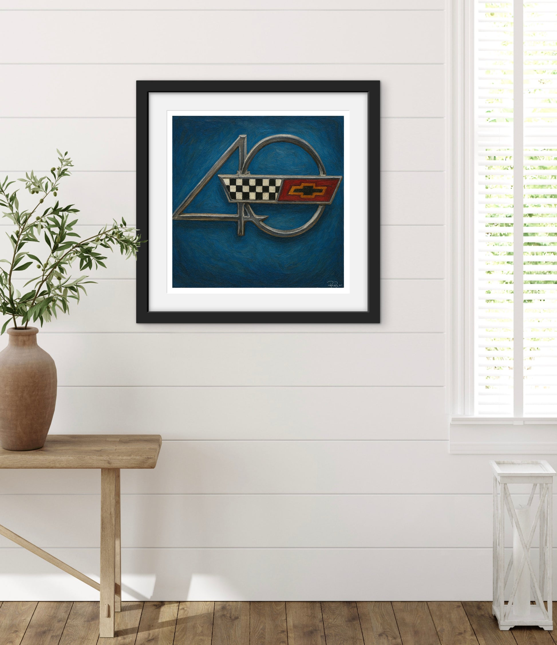Framed artwork with a logo on a white wall with wooden floor