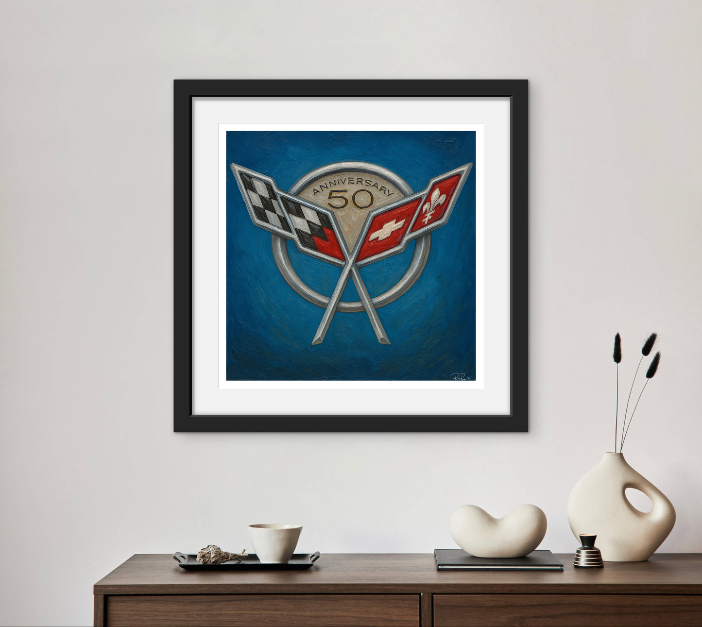 Framed artwork with racing flags on a blue background, displayed on a wall above a wooden console table.