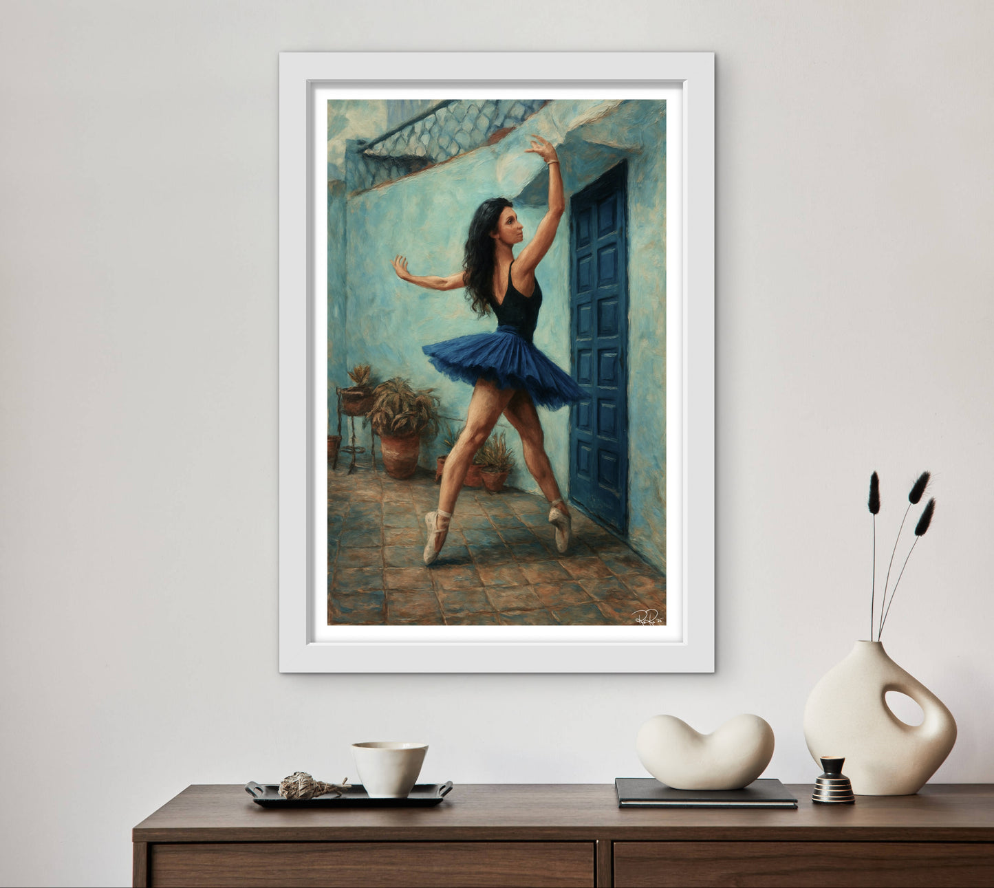 Framed artwork of a dancer in a blue tutu on a wall above a wooden console table with decorative items.