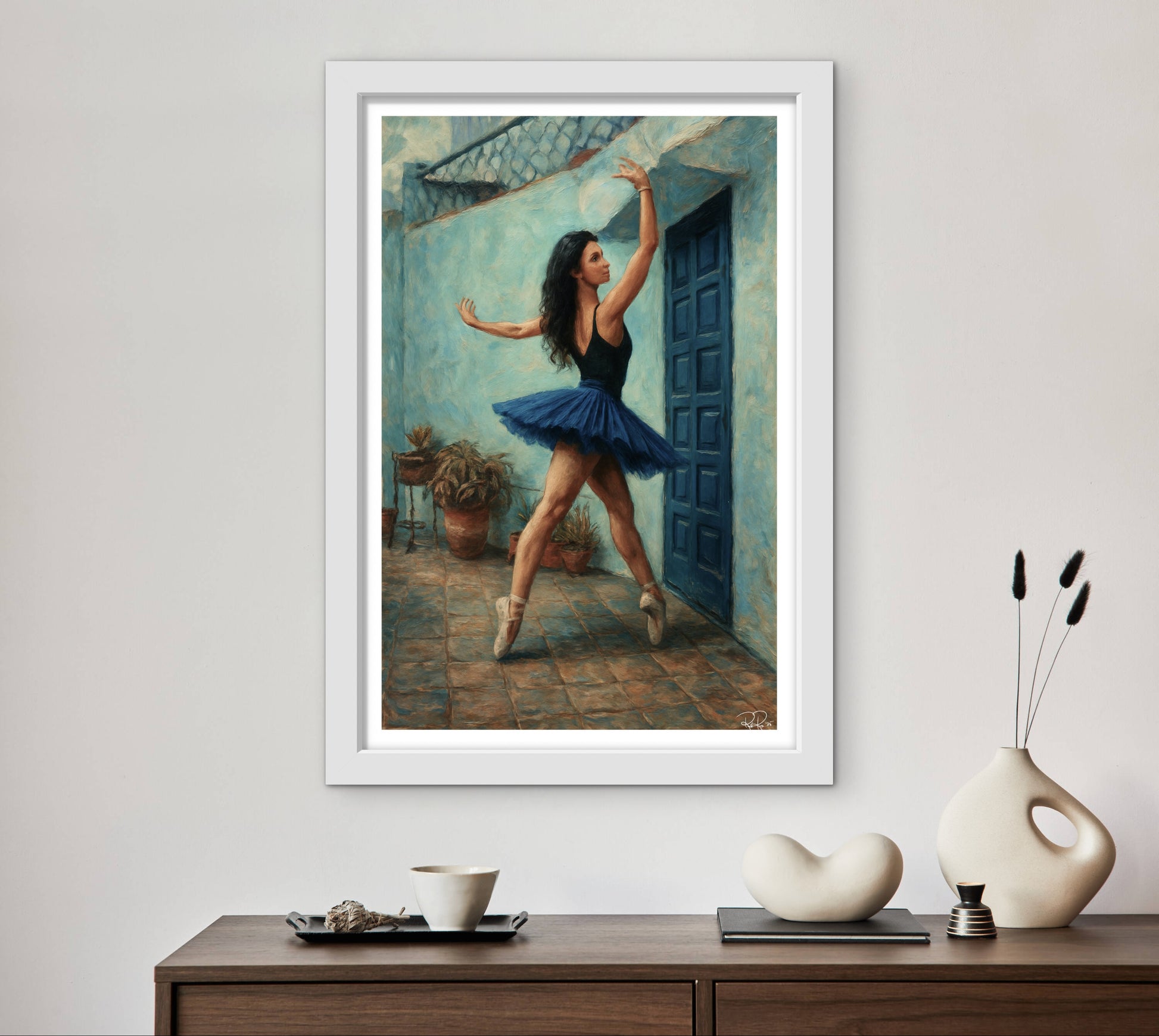 Framed artwork of a dancer in a blue tutu on a wall above a wooden console table with decorative items.