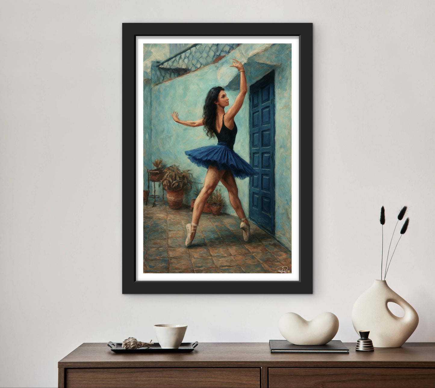 Framed artwork of a dancer in a blue tutu on a wall above a wooden console table with decorative items.