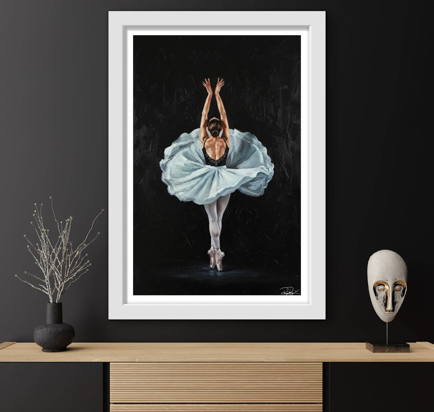 Framed artwork of a ballerina in a blue tutu against a black background, displayed on a wooden shelf with decorative items.