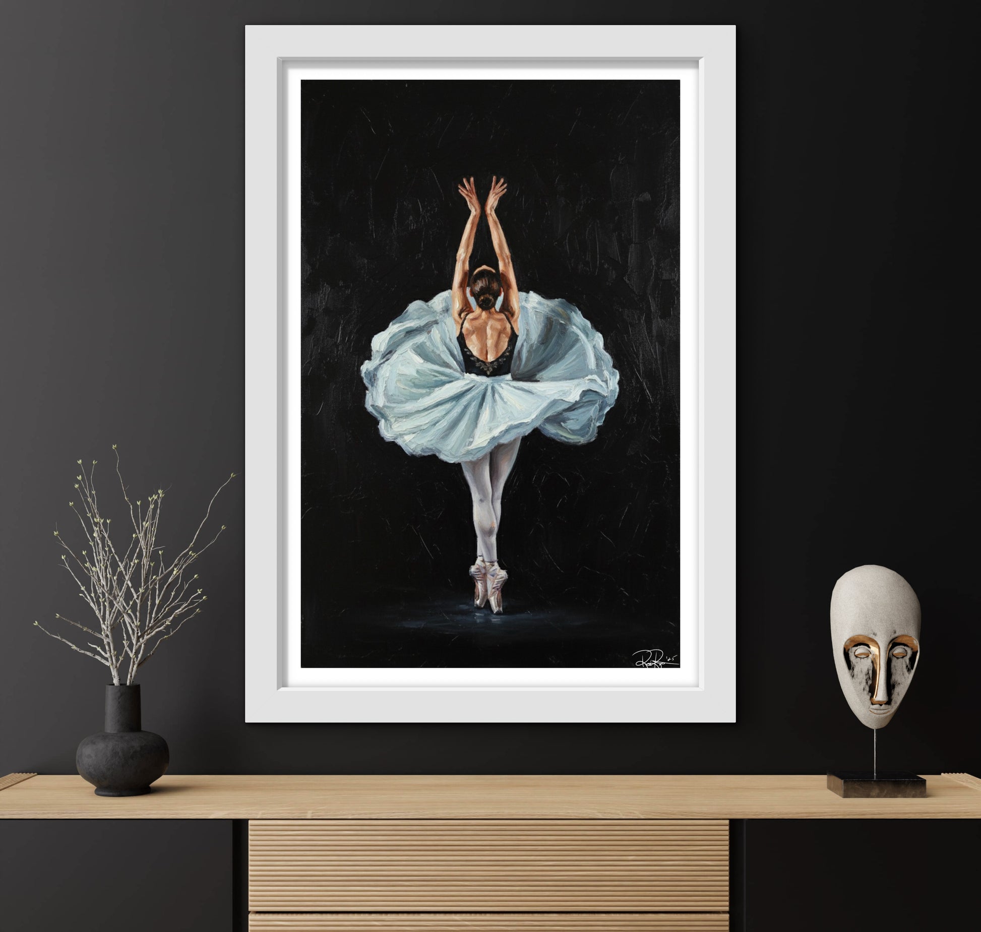 Framed artwork of a ballerina in a blue tutu against a black background, displayed on a wooden shelf with decorative items.