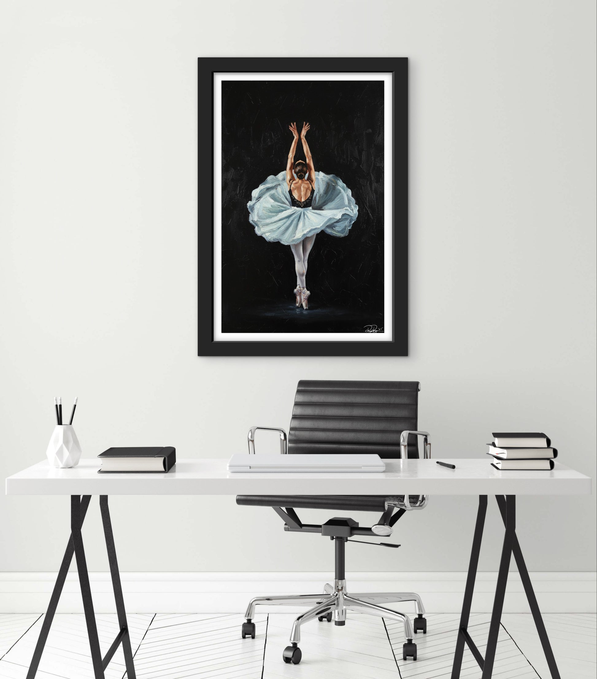 Framed artwork of a dancer in a blue dress on a wall above a desk.